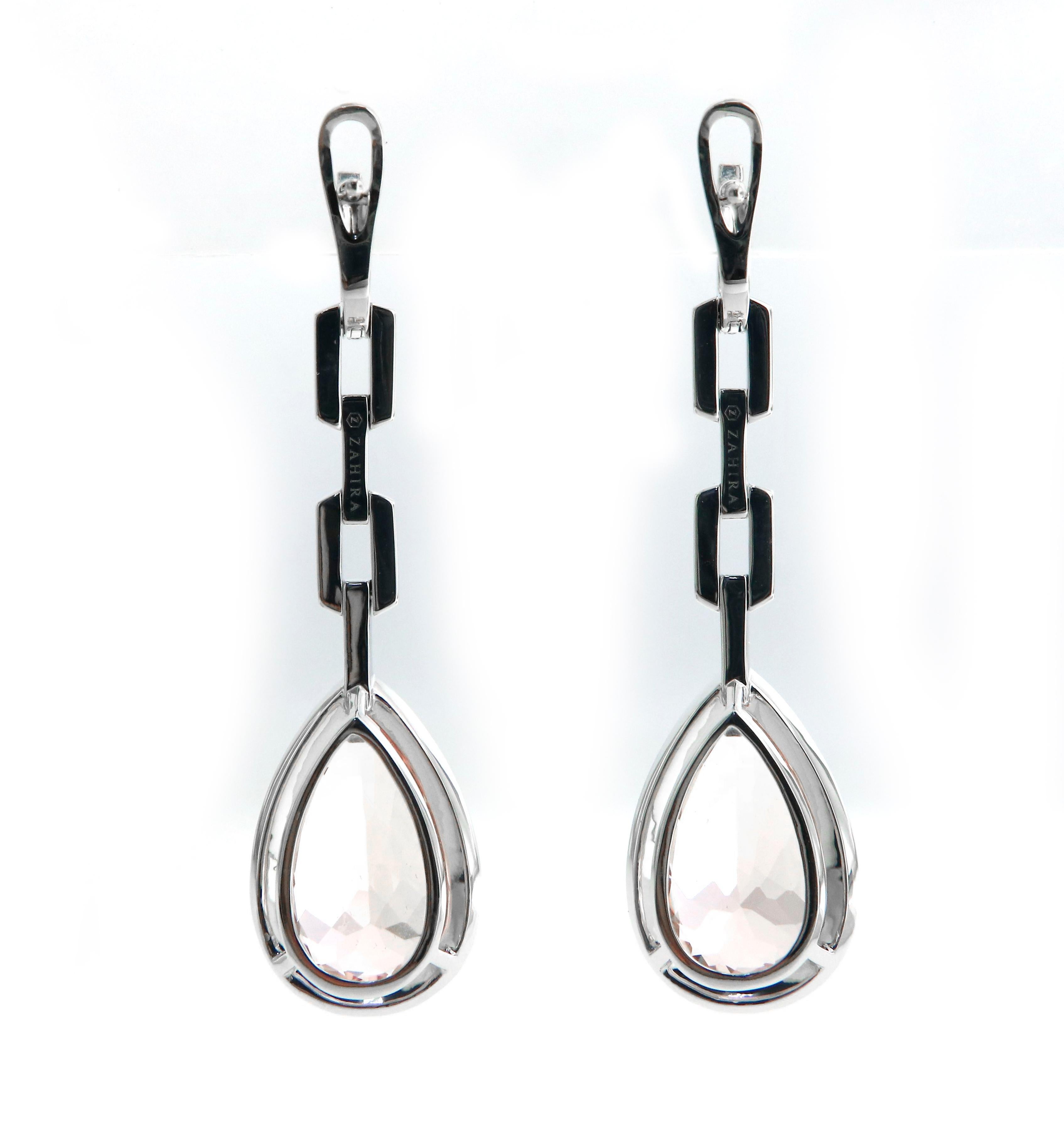 This is a pair of pear-shaped Morganite drop earrings with pave' diamonds set in 18k white gold. The Morganite gemstones are prong set and surrounded by a halo of vvs quality diamonds. The chain-link design is clean with moving hinges and are also