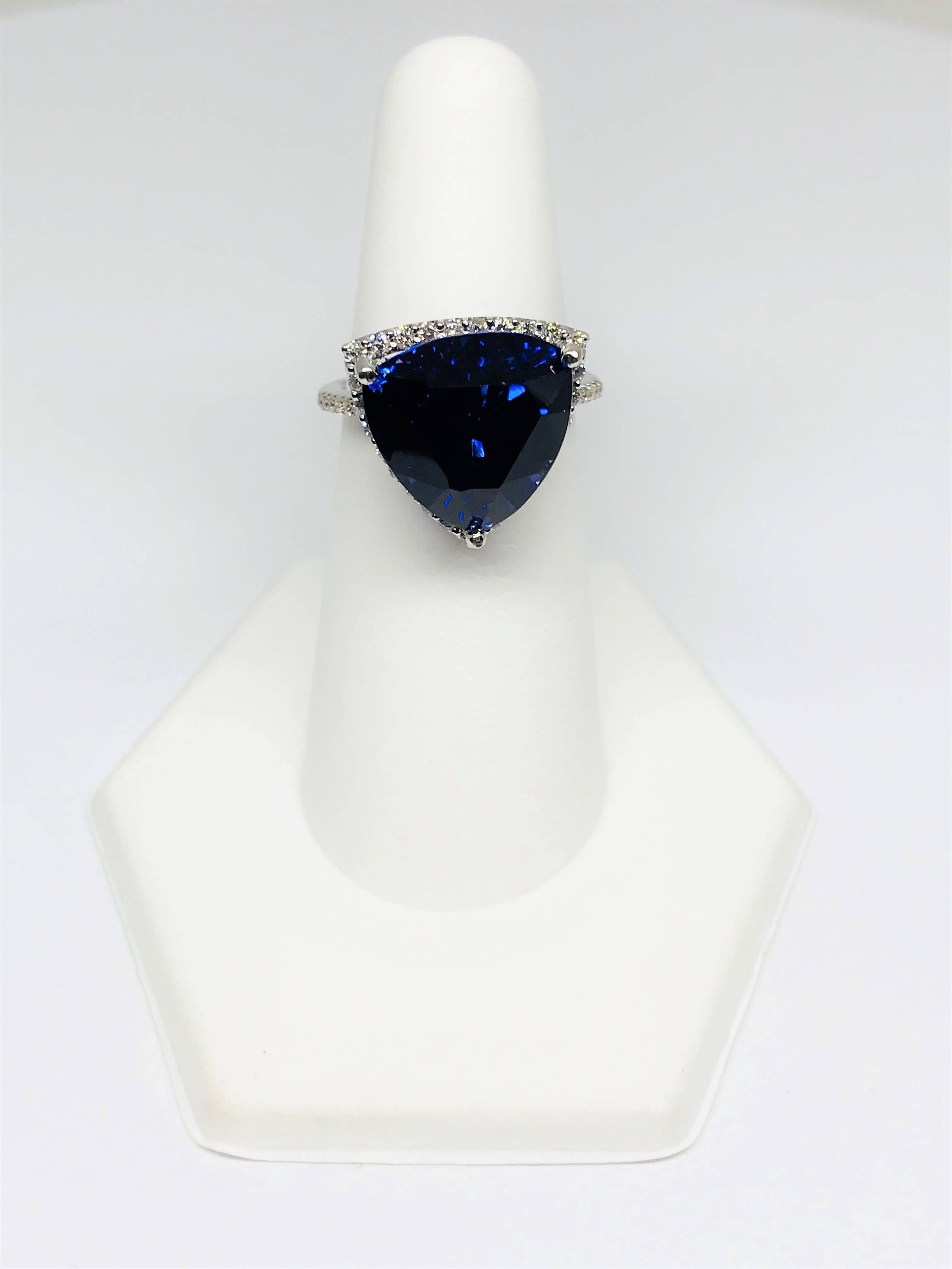 Stunning trillion shape natural 11.71 carat Tanzanite and Diamond halo 14k white gold ring. The Tanzanite measures 13.00 x 13.00 mm! It is a gorgeous vivid violetish ink blue color with strong saturation and medium tone. The halo and shoulder are