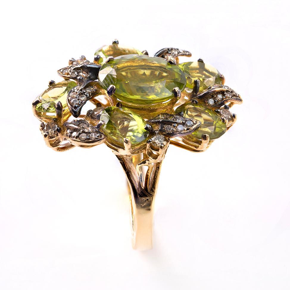 Green Peridot Flower Ring set in 18 Karat Yellow Gold with Black Oxydized Gold Leaves set with 2.70 Carat of Brown Diamonds, SI Clarity. The Ring Size is 53 and can be easily Resized.
