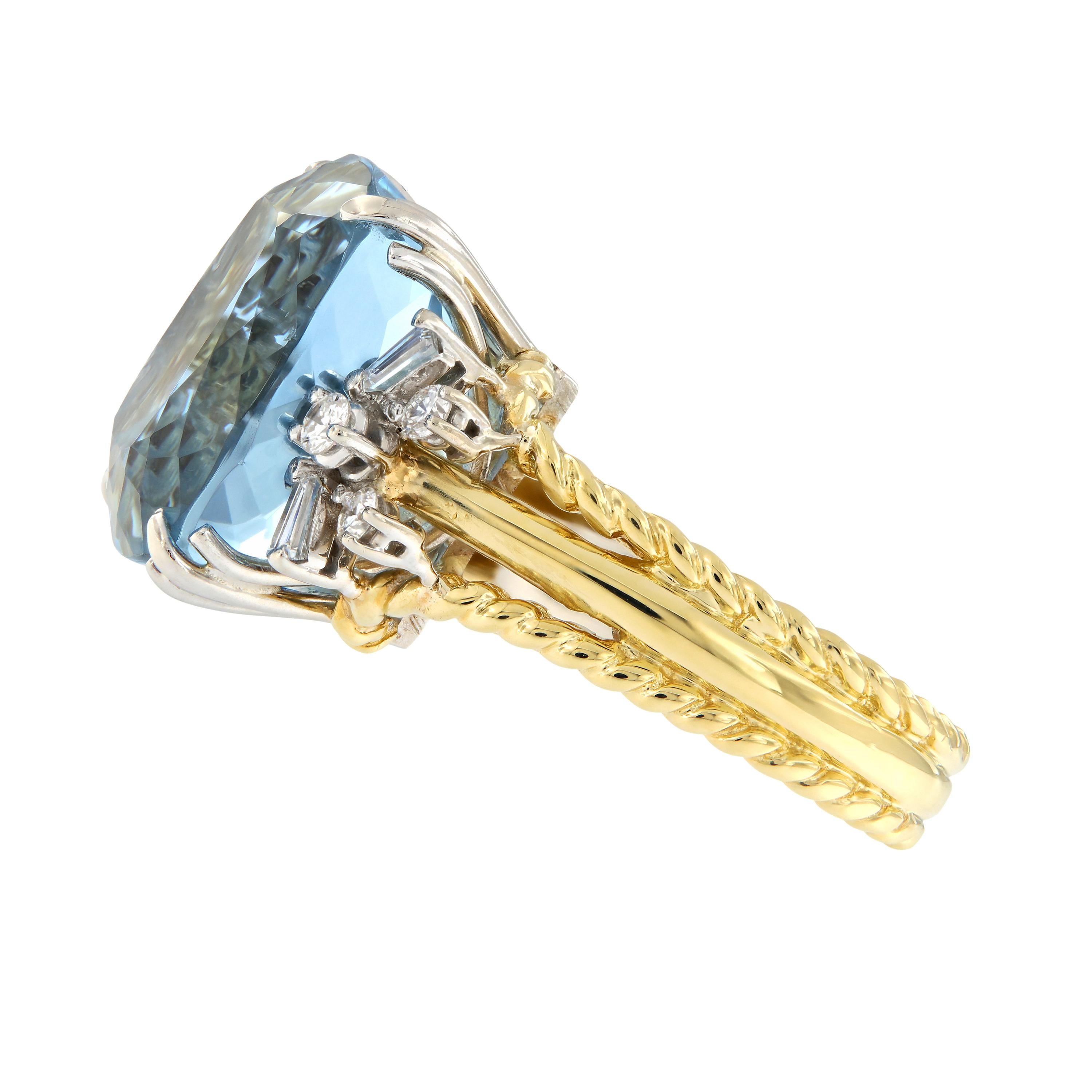 This statement cocktail ring centers around a 11.75-carat natural aquamarine of exceptional color! The center stone is a generously sized cushion cut aquamarine accented with round and baguette diamonds. The ring is crafted in 18k white and yellow