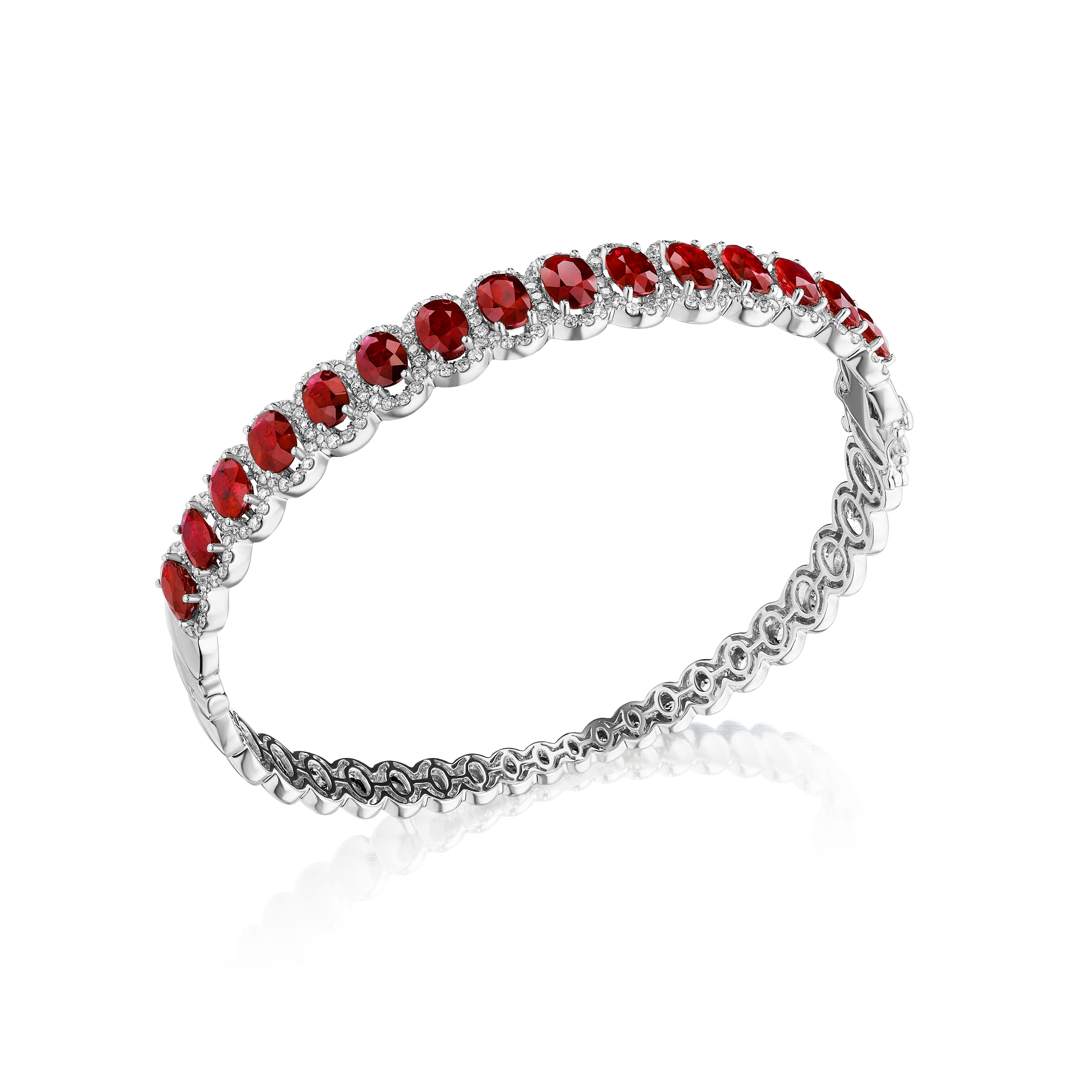 •	A truly exquisite assortment of 15 oval cut deep red rubies is framed by delicate halos made of round brilliant cut diamonds in this beautiful bangle. The stones are set in 14KT white gold and have a combining total weight of approximately 11.85