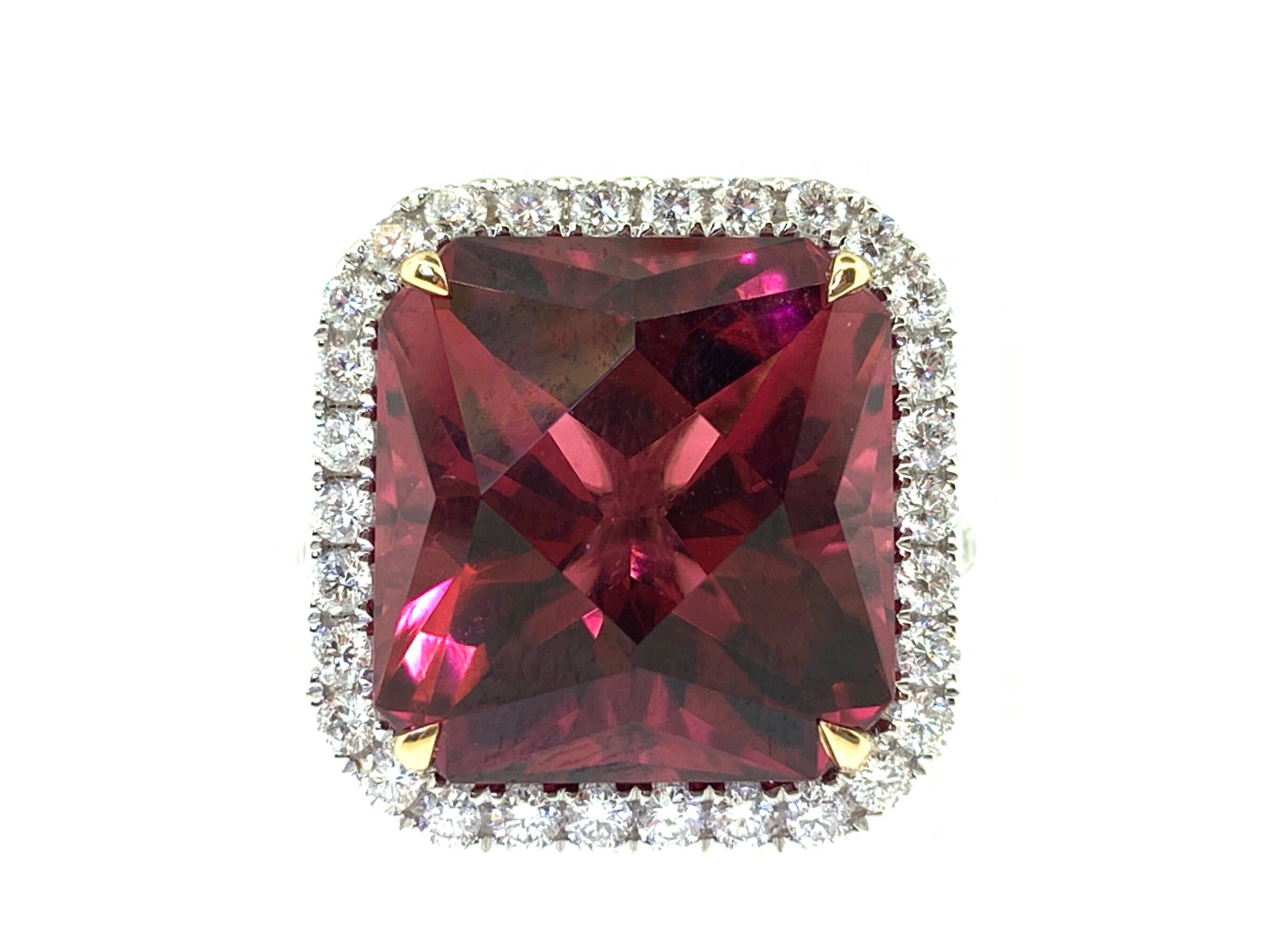 This stunning cocktail ring features a beautiful 11.76 Carat Emerald Cut Rubellite Tourmaline with a Diamond Halo and sits on a Diamond Shank. The ring is set in 18k white gold. with 18k yellow gold prongs on the center stone. Ring size is 6 1/2.