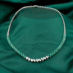 Collana “tennis” con smeraldo dello Zambia da 11,76 ct e diamanti naturali da 6,94 ct, in oro bianco 18 carati