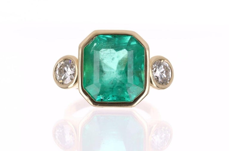 Designed and created by Jorge Rodriguez. Dexterously crafted in fine 18K yellow gold, this ring features a high quality, 10.42-carat natural Colombian emerald, emerald cut from the famous Muzo mines. Set in a secure bezel setting for extra