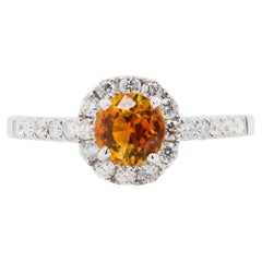 Anello di fidanzamento con zaffiro arancione da 1,17 carati e diamante aureolato in oro bianco 18 carati