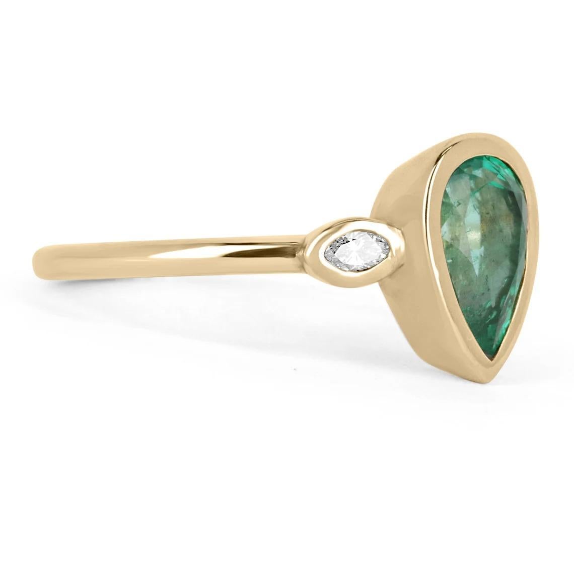 A petite pear emerald & marquise diamond three-stone bezel ring. This classic has a beautiful 1.05-carat, Zambian emerald-pear cut. The center store displays a stunning medium green color and minor internal flaws that every earth-mined gem usually