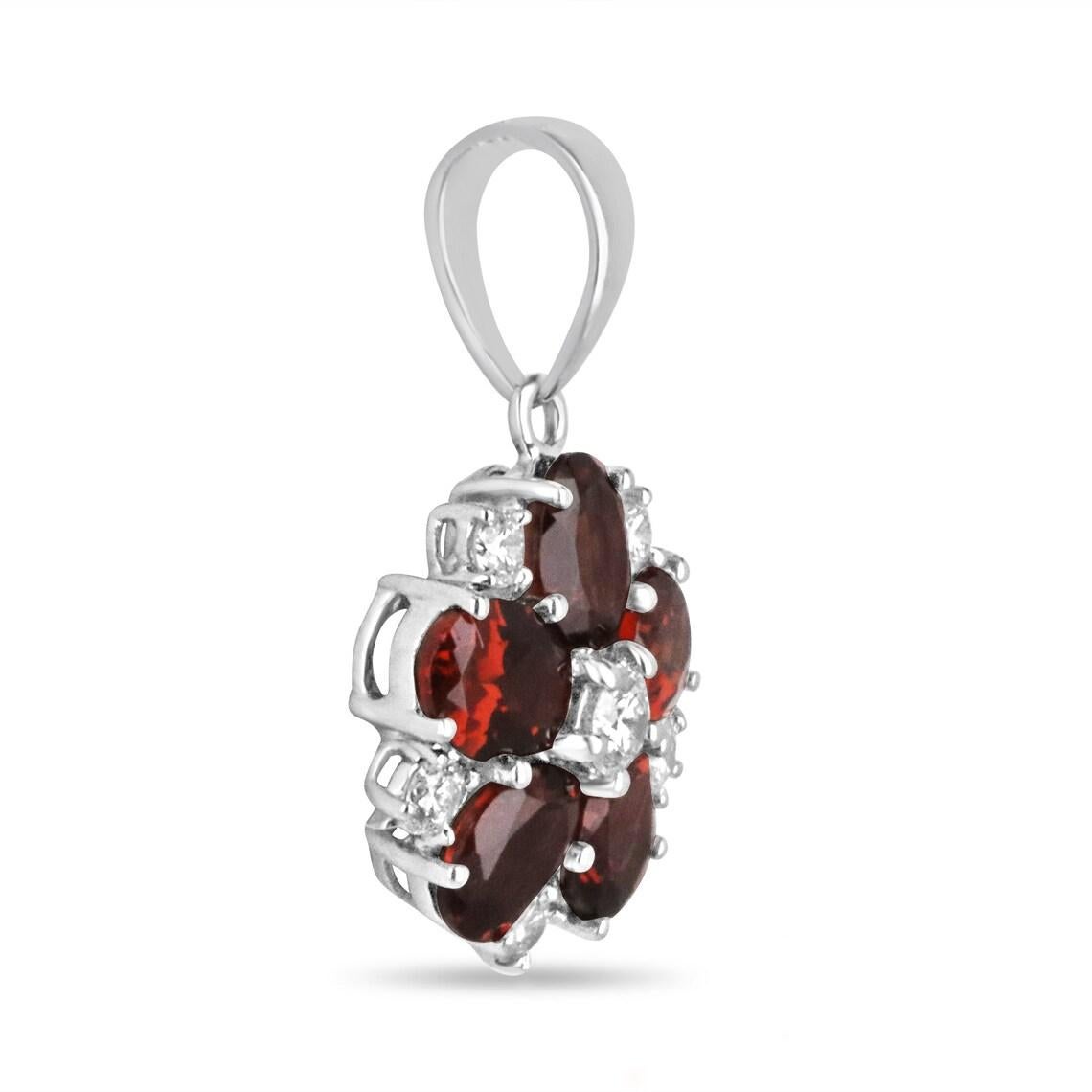 Lassen Sie sich von der Schönheit der Natur verzaubern mit diesem floralen Anhänger mit Granat und Diamant. Ein brillanter Diamant im Rundschliff steht im Mittelpunkt, umgeben von fünf bezaubernden Granaten im Ovalschliff in einem fesselnden dunklen