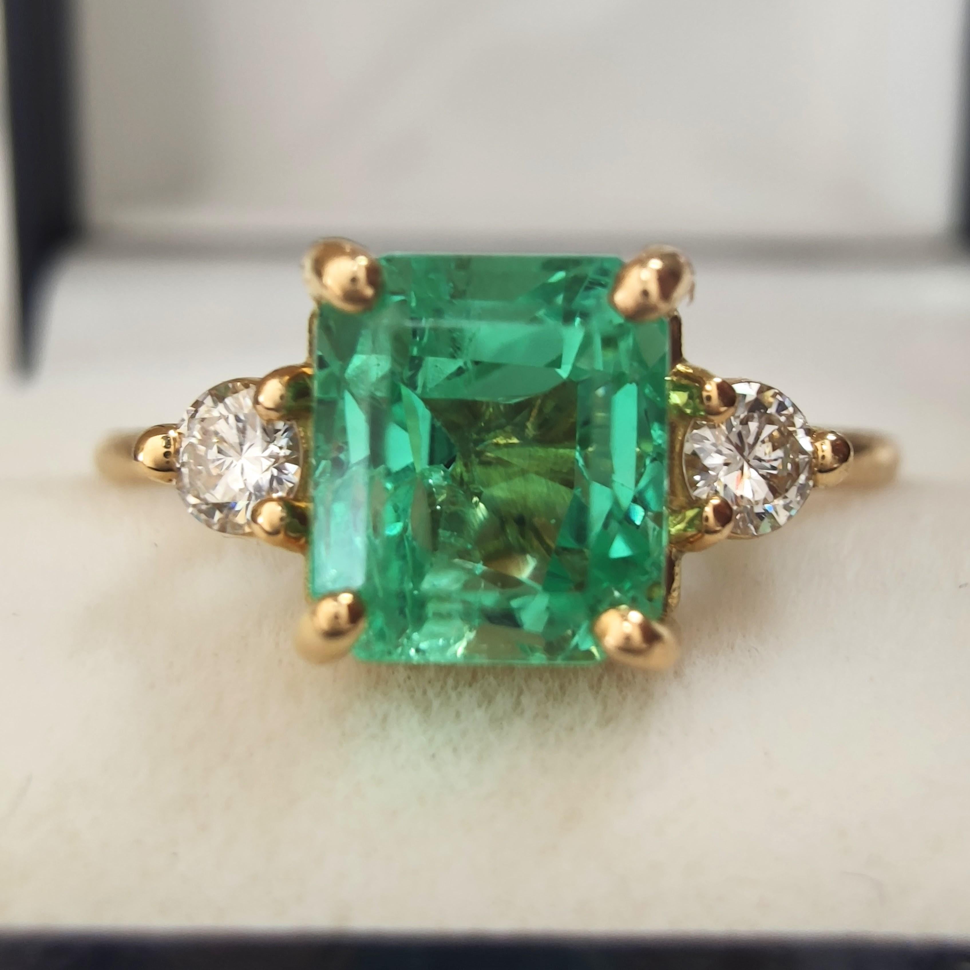1.18ct Emerald and Diamond Three-Stone Ring in 18K Yellow Gold – Handmade Design

This handcrafted three-stone ring in solid 18K yellow gold features a luminous 1.18-carat natural emerald at its center, cut in an elegant emerald shape with a notably