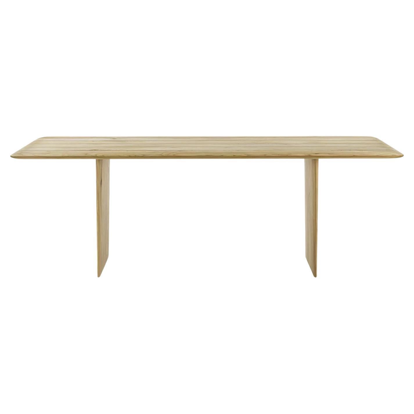 La table est entièrement fabriquée en bois de cèdre massif parfumé, avec des côtés lisses et arrondis. Son plateau et ses pieds ont une apparence élancée grâce aux bords biseautés et arrondis, ce qui lui confère un design gracieux et fluide. Le