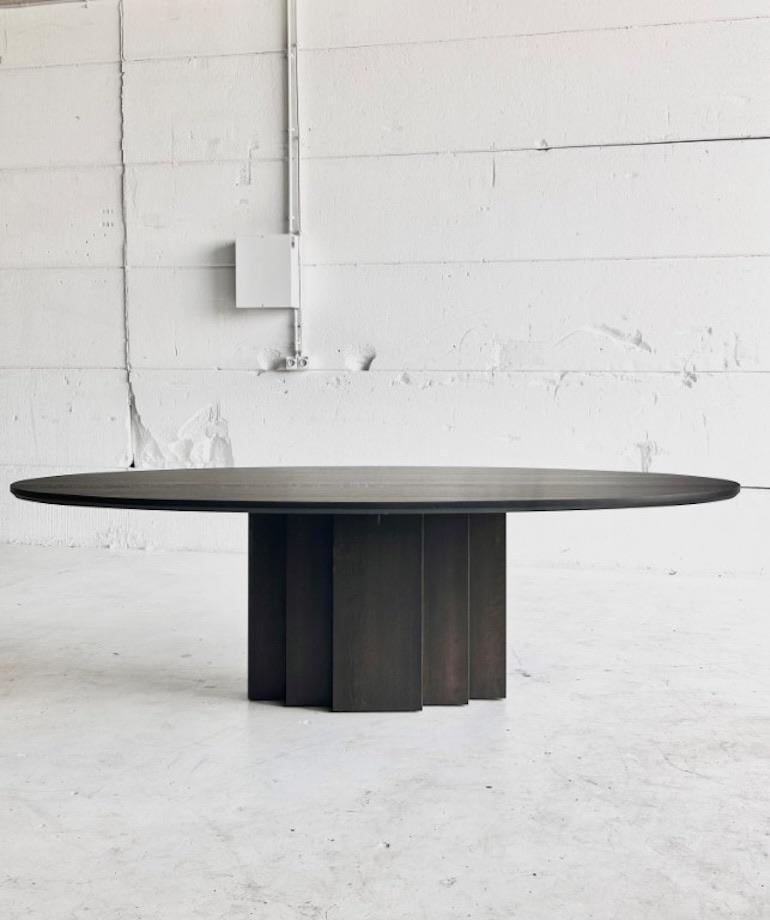 Massive table de salle à manger belge en chêne massif au design moderne, aux formes épurées et au piètement sculptural. Cette table robuste est fabriquée à la main en chêne durable. Une table avec laquelle on peut vieillir et partager des histoires.