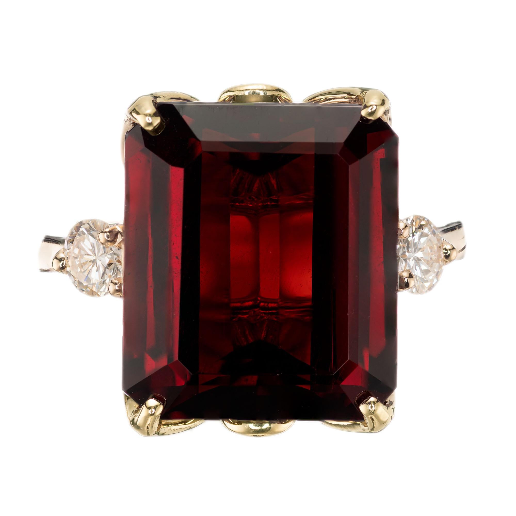 Emerald cut 11.85 carat garnet center stone with 2 round brilliant cut diamonds in a three stone 14k yellow gold setting. circa 1960  

1 emerald cut brownish red garnet, approx. 11.85cts
2 round brilliant cut diamonds, H SI approx. .33cts 
Size