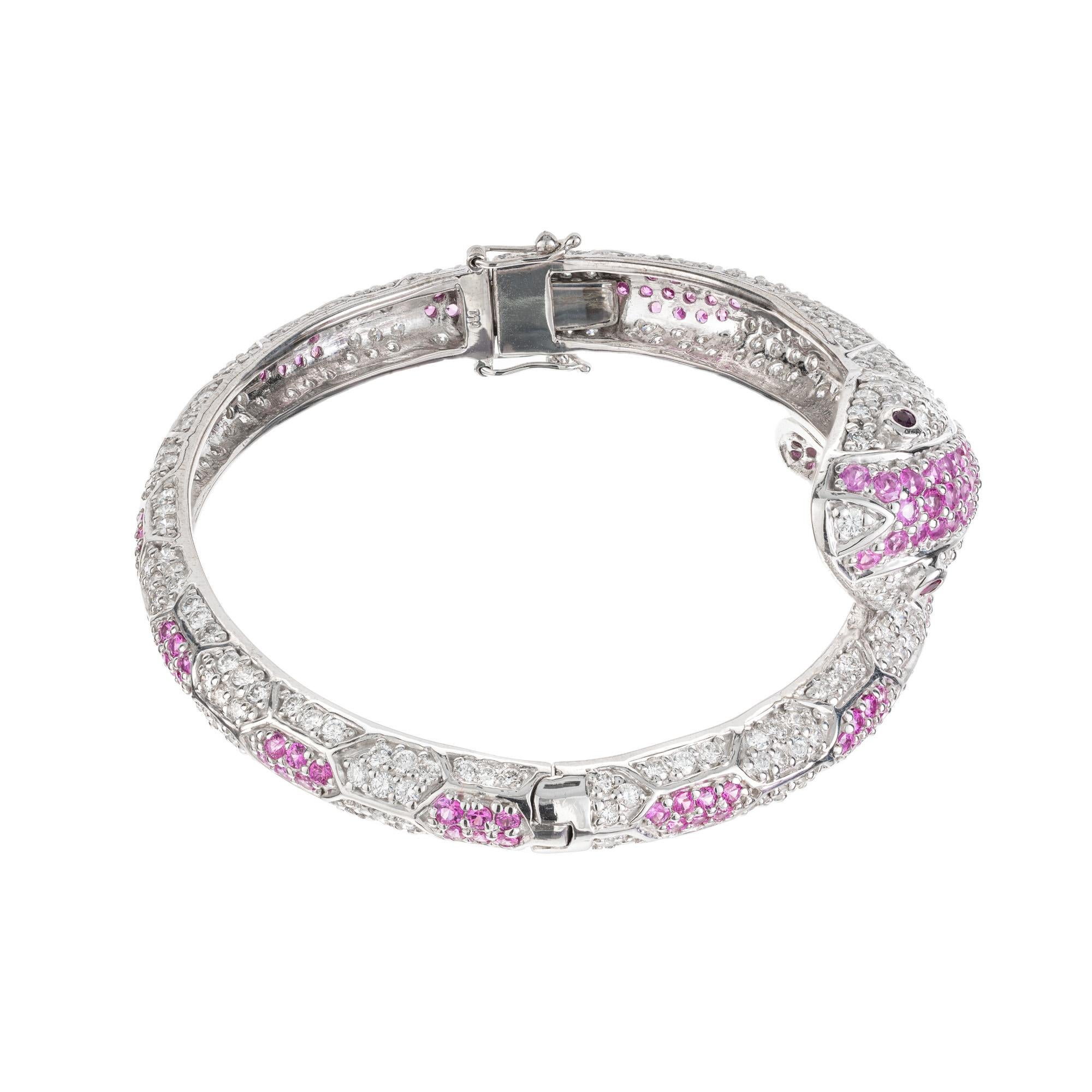 Ruby, diamond and sapphire snake hinged bangle bracelet. Simply spectacular. This 18k white gold bracelet is adorned with 151 pink round sapphires with and approximate total weight of 3.80cts. 316 full cut diamonds and 2 round red ruby eye. There is
