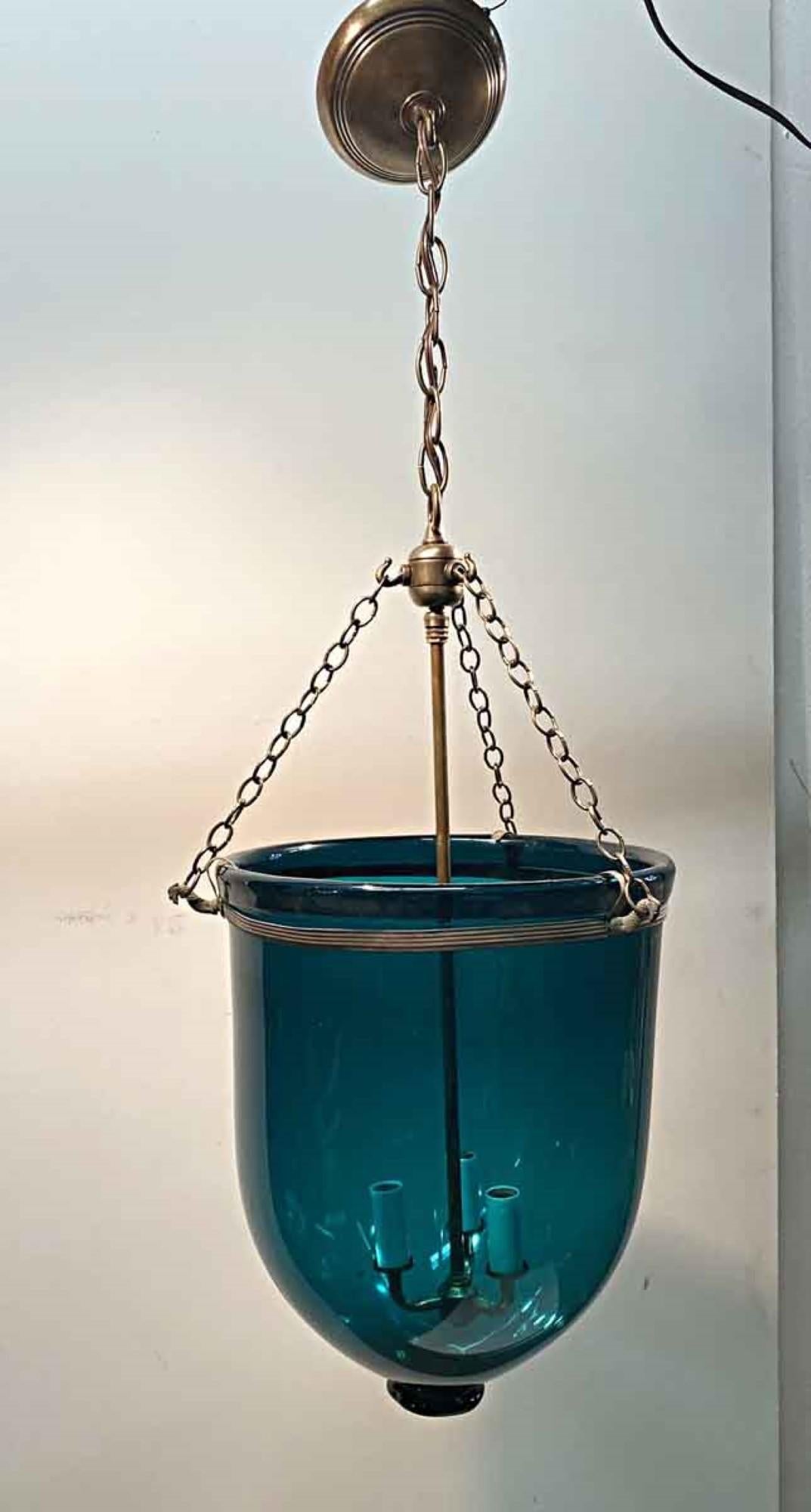1890s whale oil English hand blown glass bell jar lantern in a aqua blue color. Now electrified with new brass hardware and three candelabra lights. This can be seen at our 400 Gilligan St location in Scranton. PA.