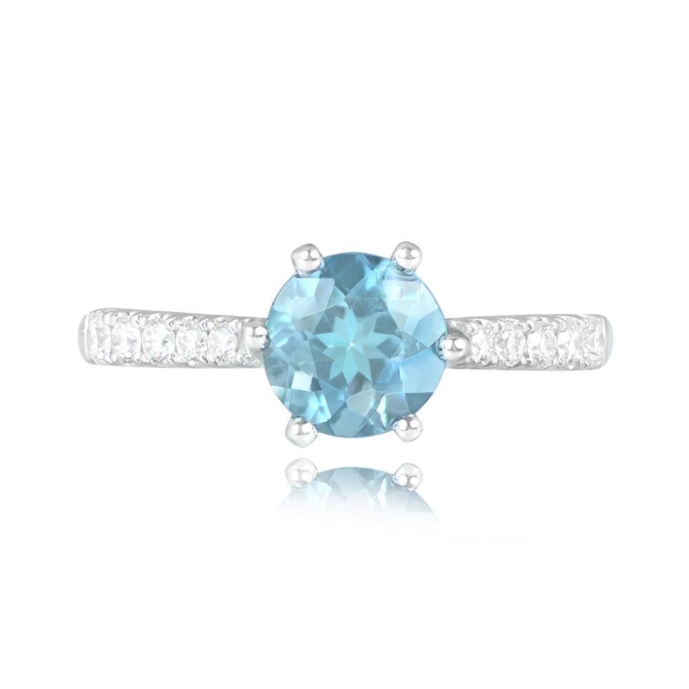 This ring showcases a 1.18-carat Santa Maria aquamarine in a round cut, prong-set in 18k white gold. Round brilliant cut diamonds adorn the shoulders, with a combined weight of approximately 0.24 carats. The aquamarine is of the Santa Maria color,