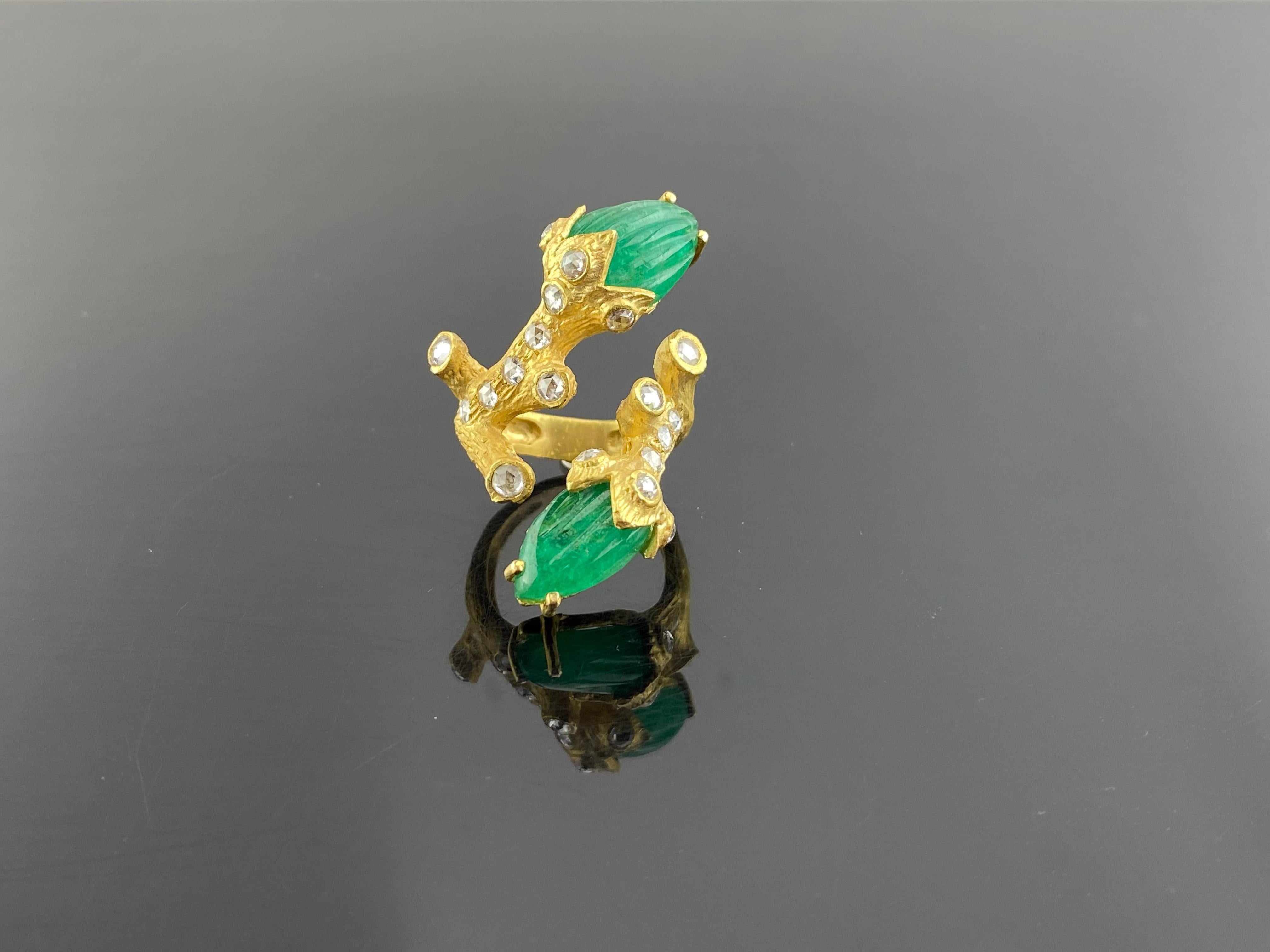 An art-deco inspired hand-carved Colombian Emerald cocktail ring set in solid matte finish 18K Yellow Gold and White Diamonds. The weight of the 2 Emerald Carvings is 11.19 carats. The Emerald is completely natural with no external treatments done