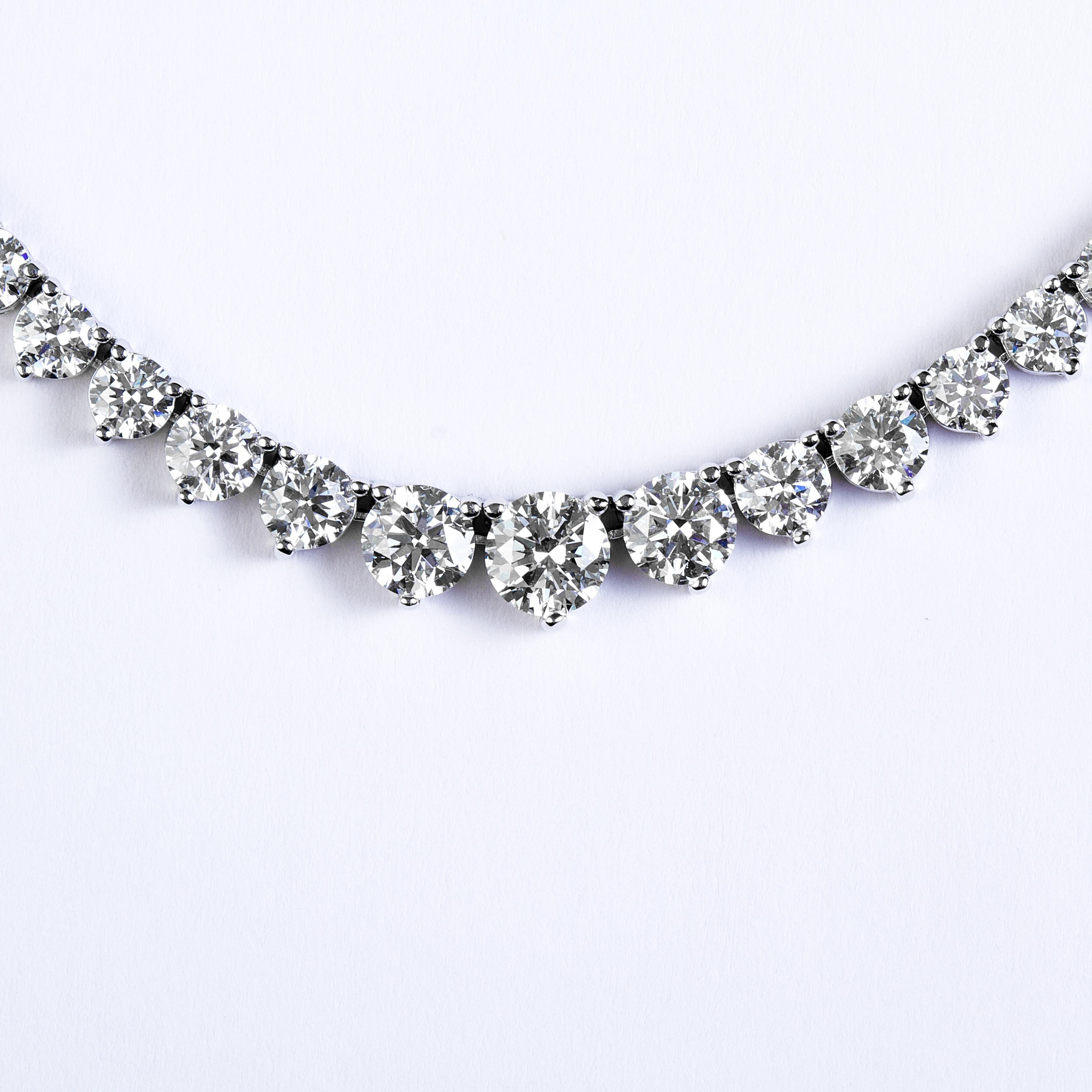 This exquisite graduated riviera necklace set in handmade 18k white gold featuring perfectly cut ideal round brilliant diamonds. the super white diamonds are in g-h-I color and VS2 clarity with a total carat weight of 11.90. This precious necklace