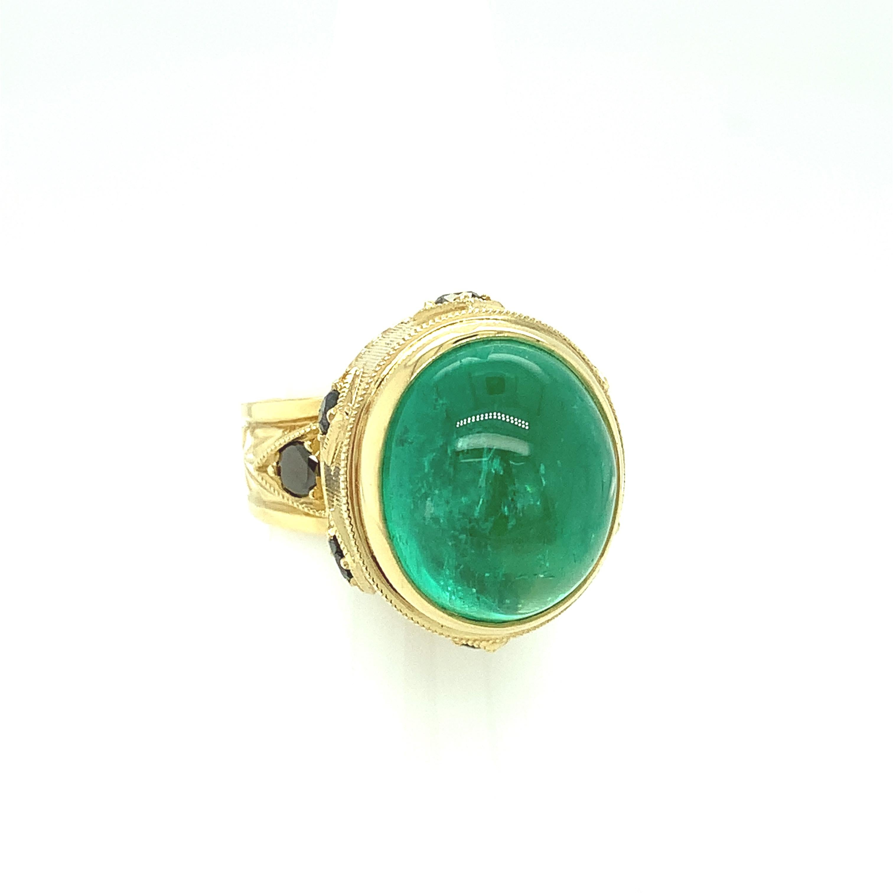 A large, beautifully crystalline, bright green emerald cabochon is featured in this gorgeous 18k yellow gold handmade ring. The ring was custom made for this gemstone in the design of one of our most popular signature styles - a beautiful