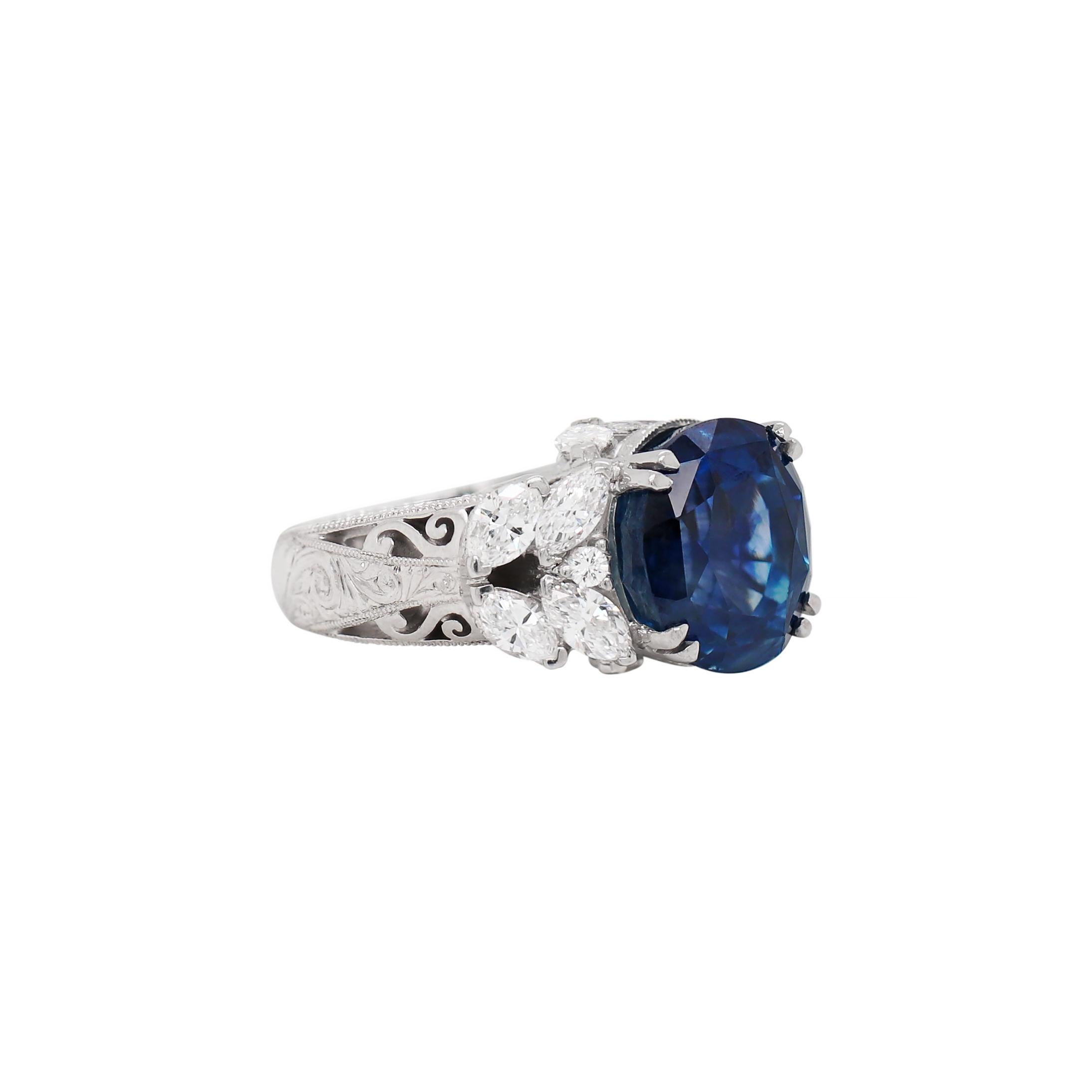 A one of a kind statement ring featuring a beautiful oval cut blue sapphire weighing an impressive 11.92ct in a four double claw open back setting. The stone is mounted in the centre of an intricate open-work designed ring set with 12 fine quality