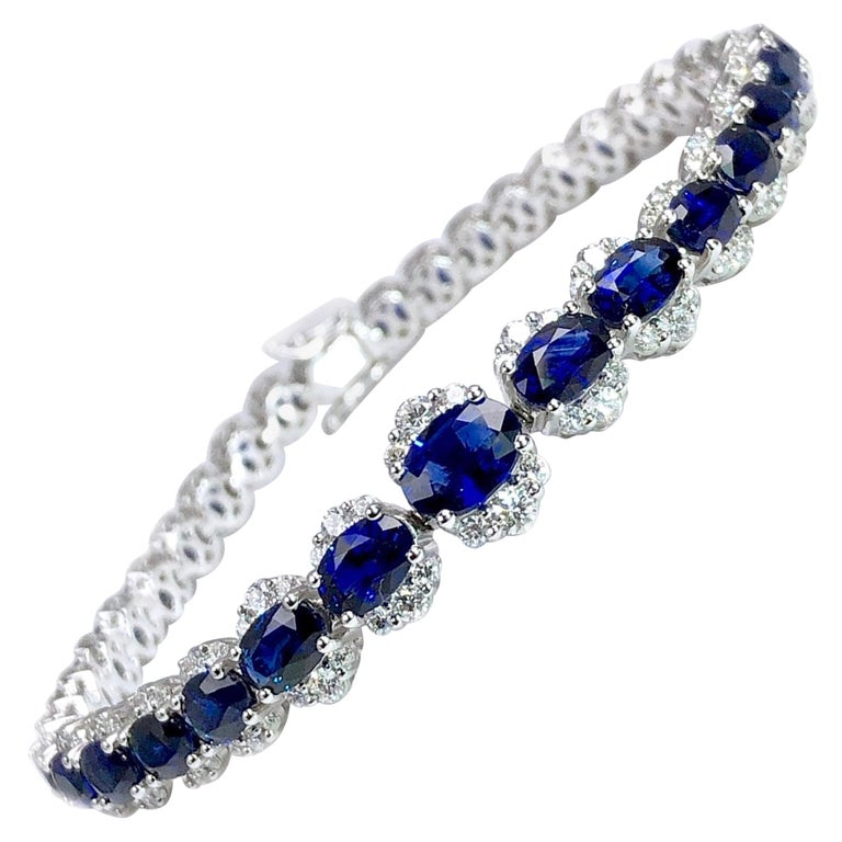 (DiamondTown) This bracelet features 37 hand selected graduated oval cut Vivid Blue Sapphires (total weight 11.93 carats) surrounded by round cut diamonds (total diamond weight 1.95 carats). The Sapphire and Diamond details carry throughout the