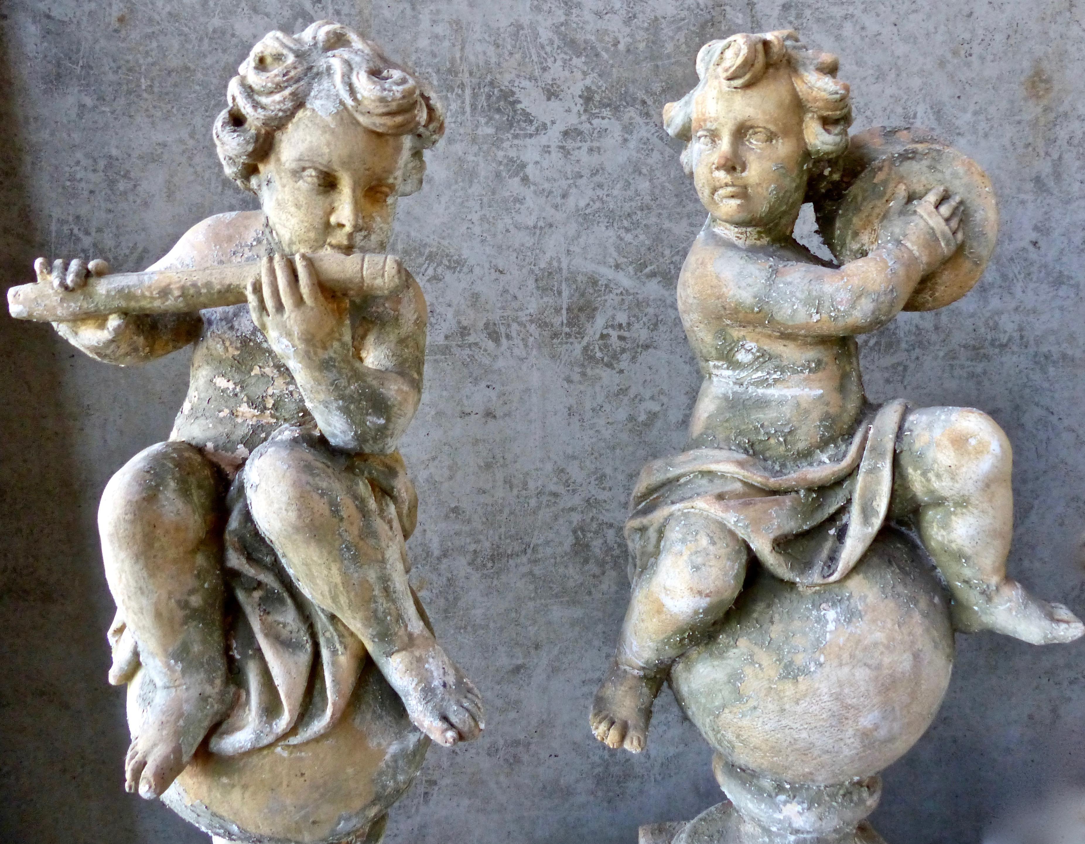 Rare set of four French hand-cast cherubs playing musical instruments: flute, cymbals, tambourine, and lute. Each member of this angelic quartet has it’s own matching but separate base. Charming and unique sculptures for that special garden.