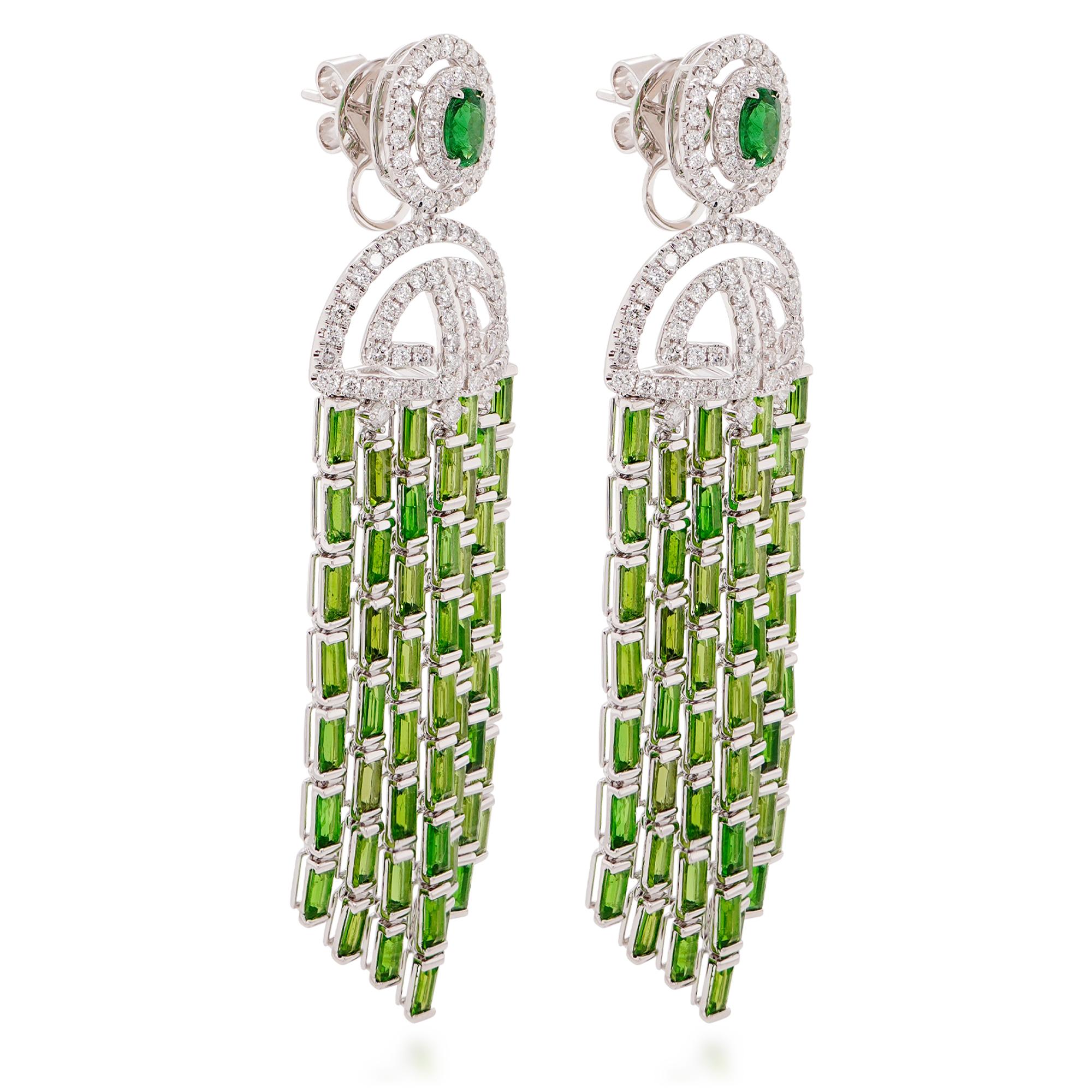 These exquisite earrings showcase the vibrant green of tsavorite garnets, totaling 11.96 carats, in a captivating dangling design. The pear-shaped tsavorites, known for their intense sparkle and brilliance, are expertly faceted to maximize their