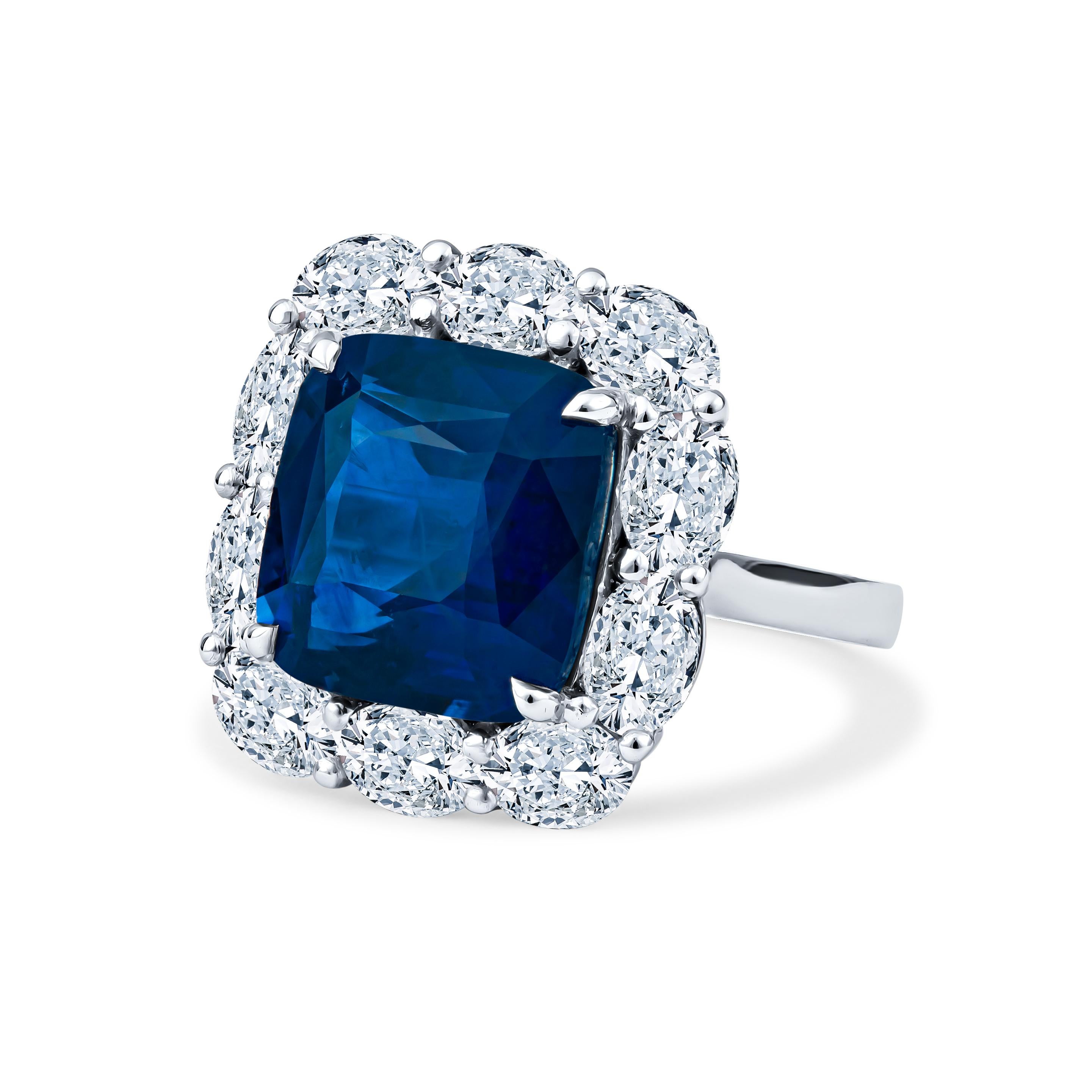 Questo splendido anello è caratterizzato da uno zaffiro naturale con taglio a cuscino da 11,98 carati (solo calore standard), circondato da un'aureola di diamanti ovali da 3,42 carati, il tutto incastonato nel platino. È una taglia 6, ma può essere