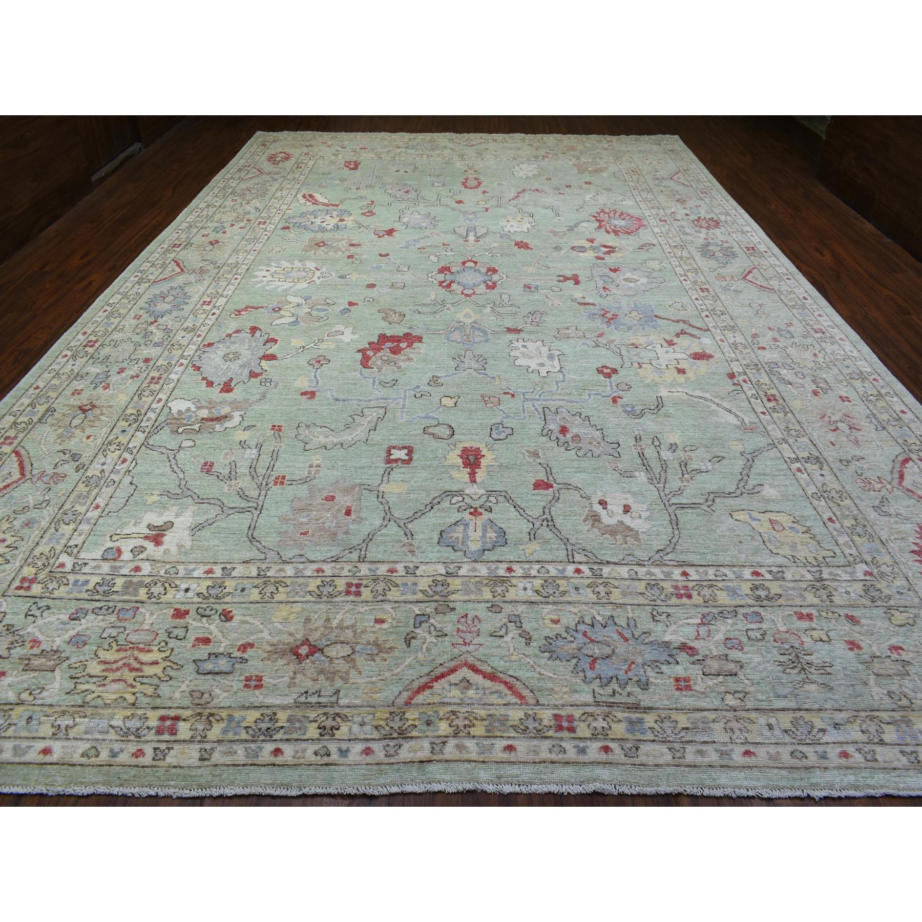 Il s'agit d'un véritable tapis oriental surdimensionné en laine douce Angora Oushak avec des motifs colorés, noué à la main et de couleur verte. Il a été noué pendant des mois et des mois selon des techniques de tissage séculaires par des artisans