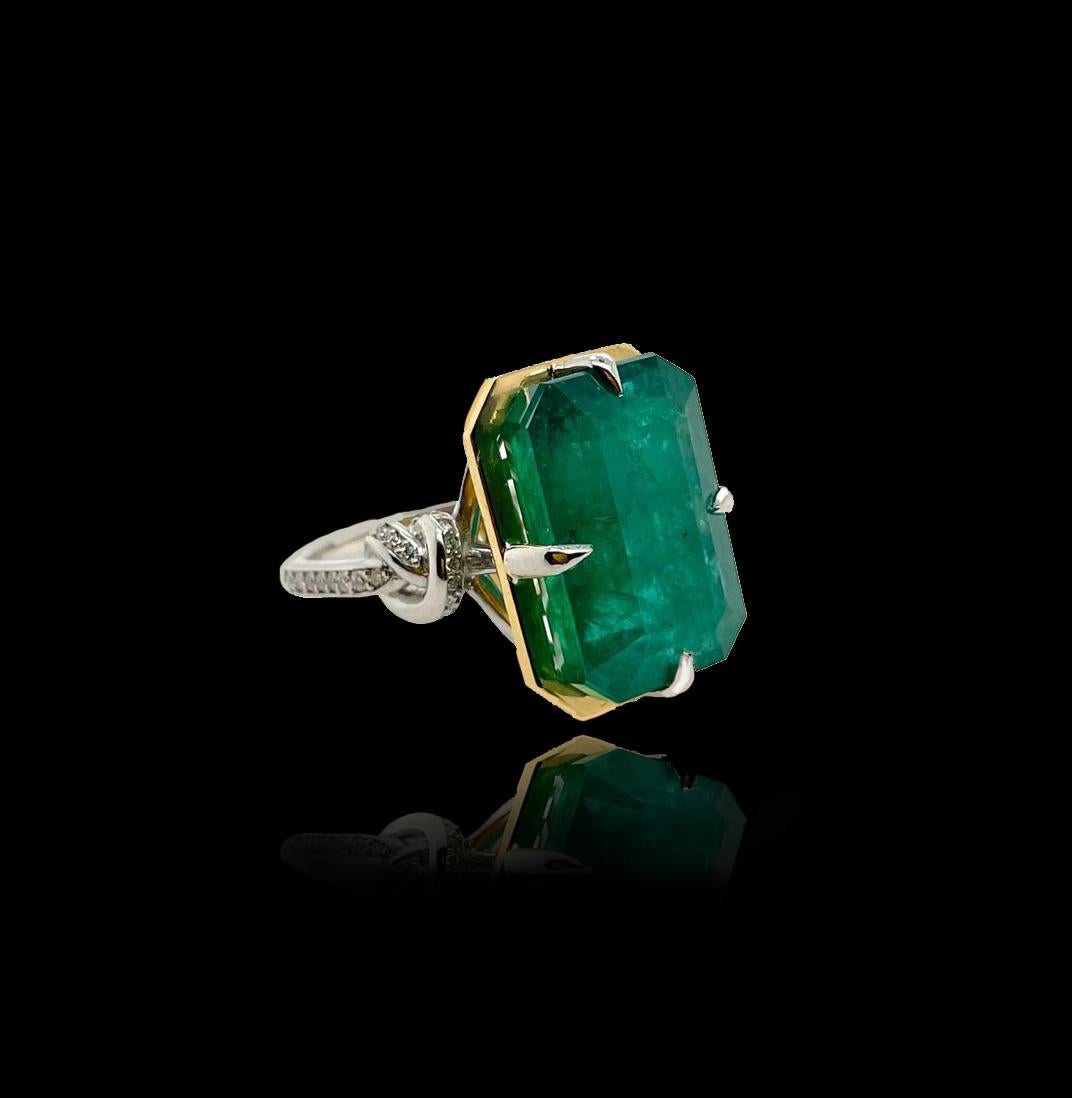 Glamorously bold and unabashedly seductive. This showstopper one of a kind ring features an intense 11ct natural Emerald poised between sharp eagle style talons and embraced by powerful-platinum, diamond encrusted ropes, converging to two knots on