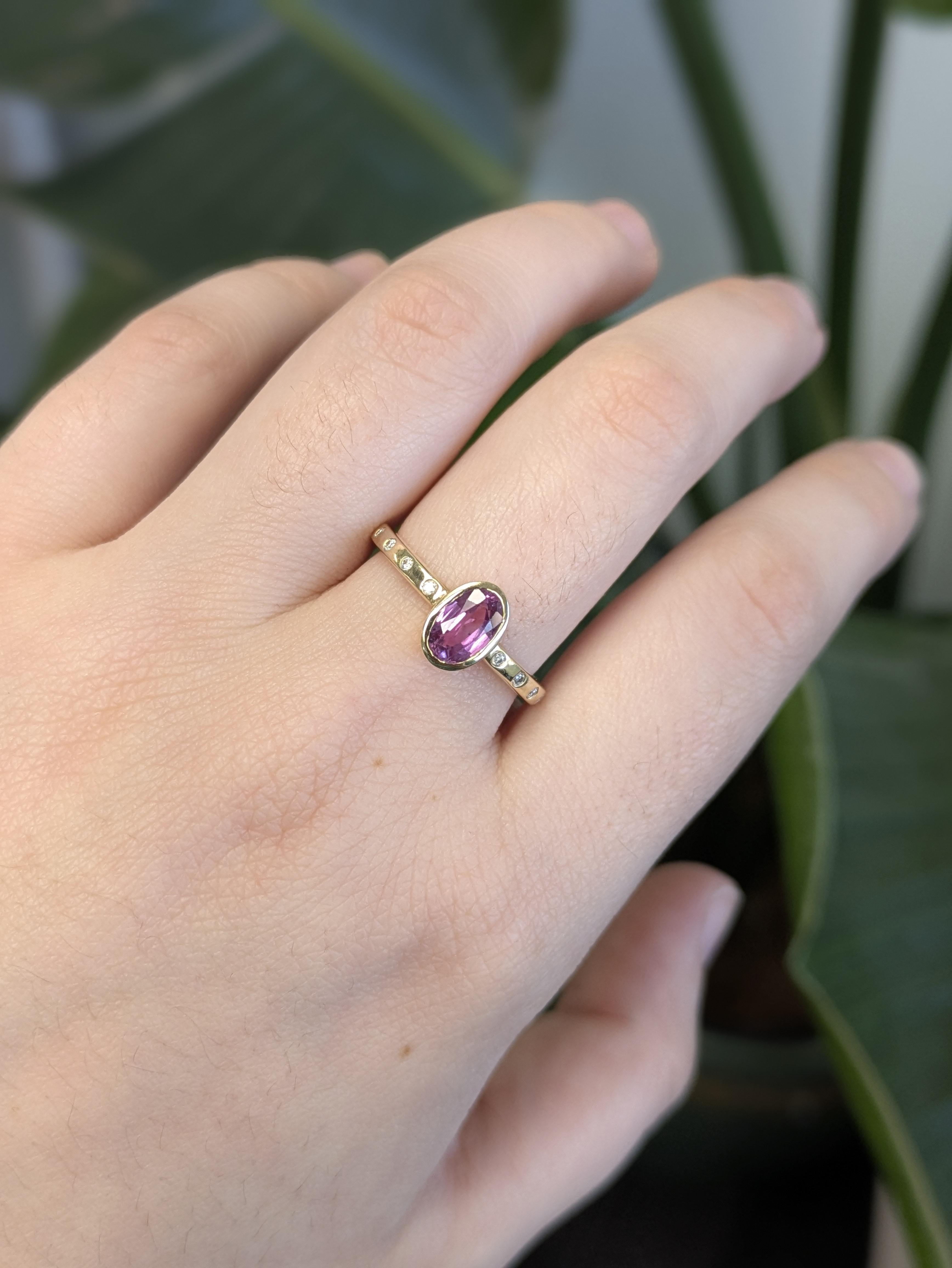 Cette éblouissante bague en or jaune massif 14 carats est ornée d'un saphir rose ovale captivant, entouré de diamants naturels qui ajoutent la bonne touche d'éclat. L'éclat chaud de l'or jaune rehausse magnifiquement la teinte romantique du saphir,