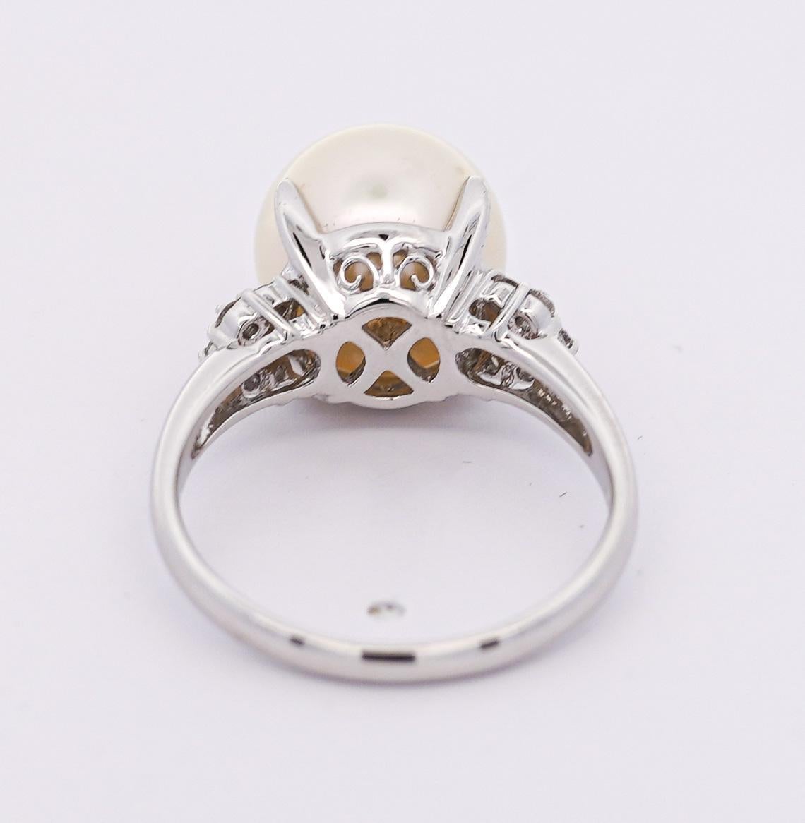 Anello con perla coltivata dei mari del sud e diamante taglio rotondo da 11 mm. Caratterizzato da uno splendido gambo in filigrana. Incastonatura in platino con anello di misura 7,25. Incastonatura sicura a 4 punte con pietre laterali di diamanti