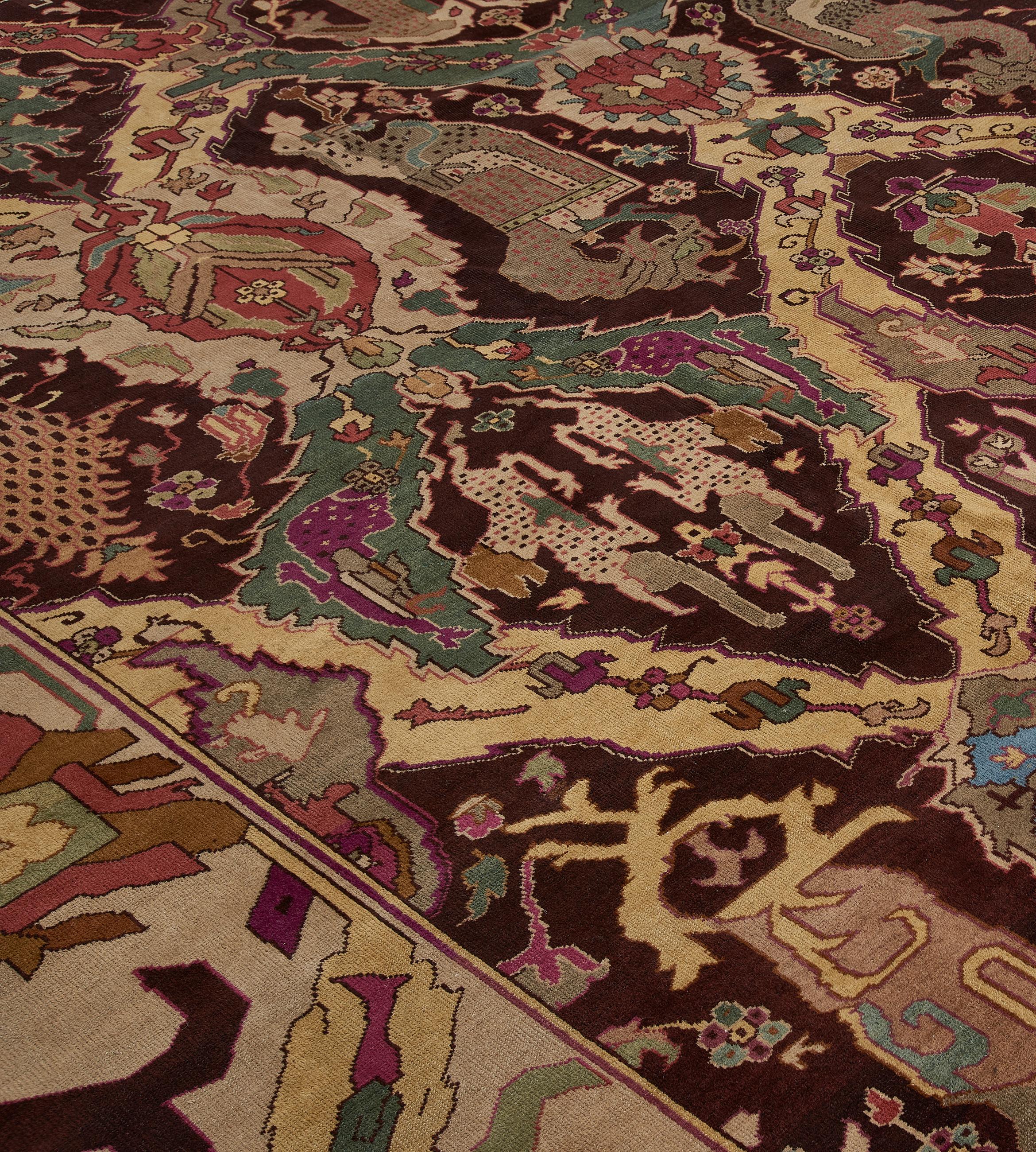 This antique, circa-1920, Indian rug has a chocolate-brown field with three bold polychrome columns of linked lozenges alternating with palmettes each with a palmette or a stylised dragon motif together with floral stems and flowerheads, in a bold