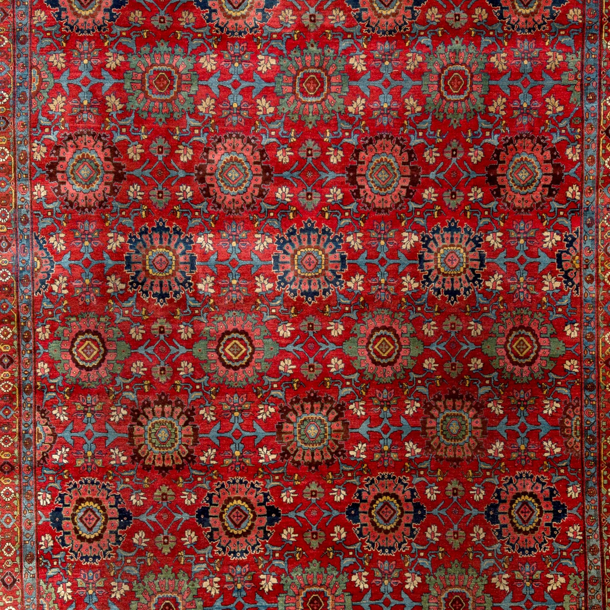 There is a certain element of cheerfulness as well as a powerful presence to this dazzling Bidjar rug with its softly rendered blossoms all-over a strikingly vivid red field. These blossoms, big and small, featured in beautifully restrained soft