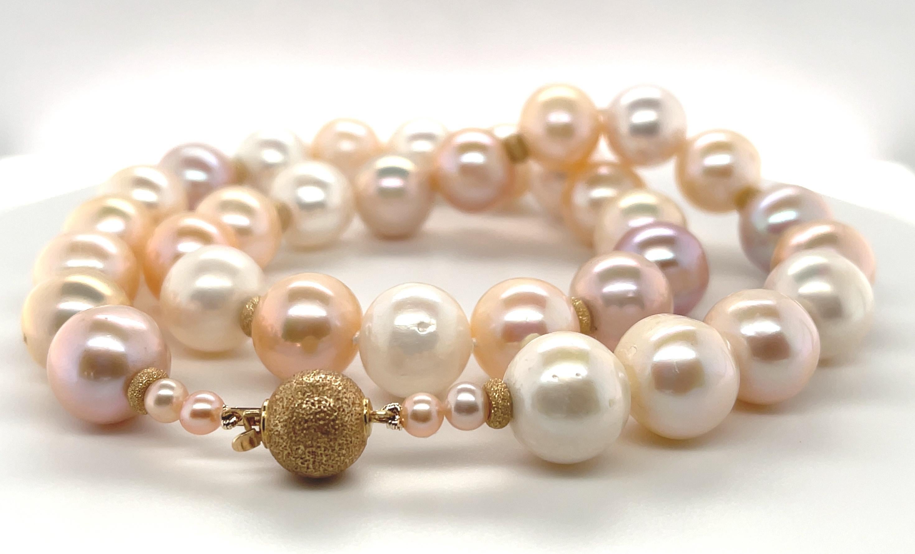 This strand of large pearls features an array of hues including Pantone's 2024 Color of The Year, fuzzy peach! A gorgeous blend of peach, white and orchid colored pearls have been hand strung with 14k yellow gold 