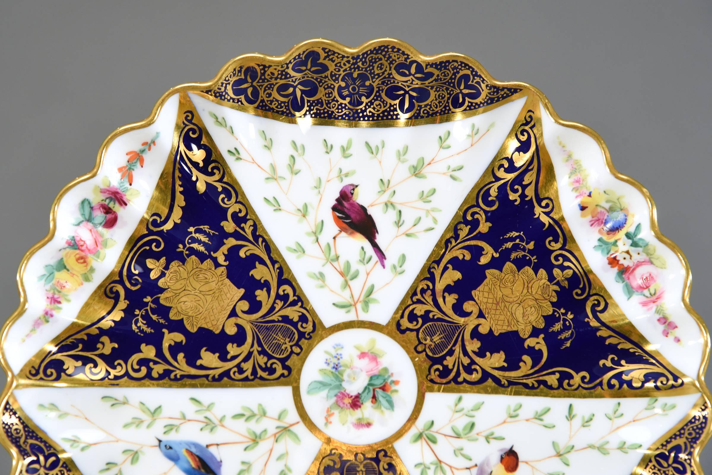 Cet ensemble de 12 jolies assiettes à dessert de mouvement esthétique Spode Copeland présente un motif géométrique accrocheur décoré de bleu cobalt, d'or en relief et, mieux encore, d'oiseaux peints à la main. Les bordures sont également ornées de