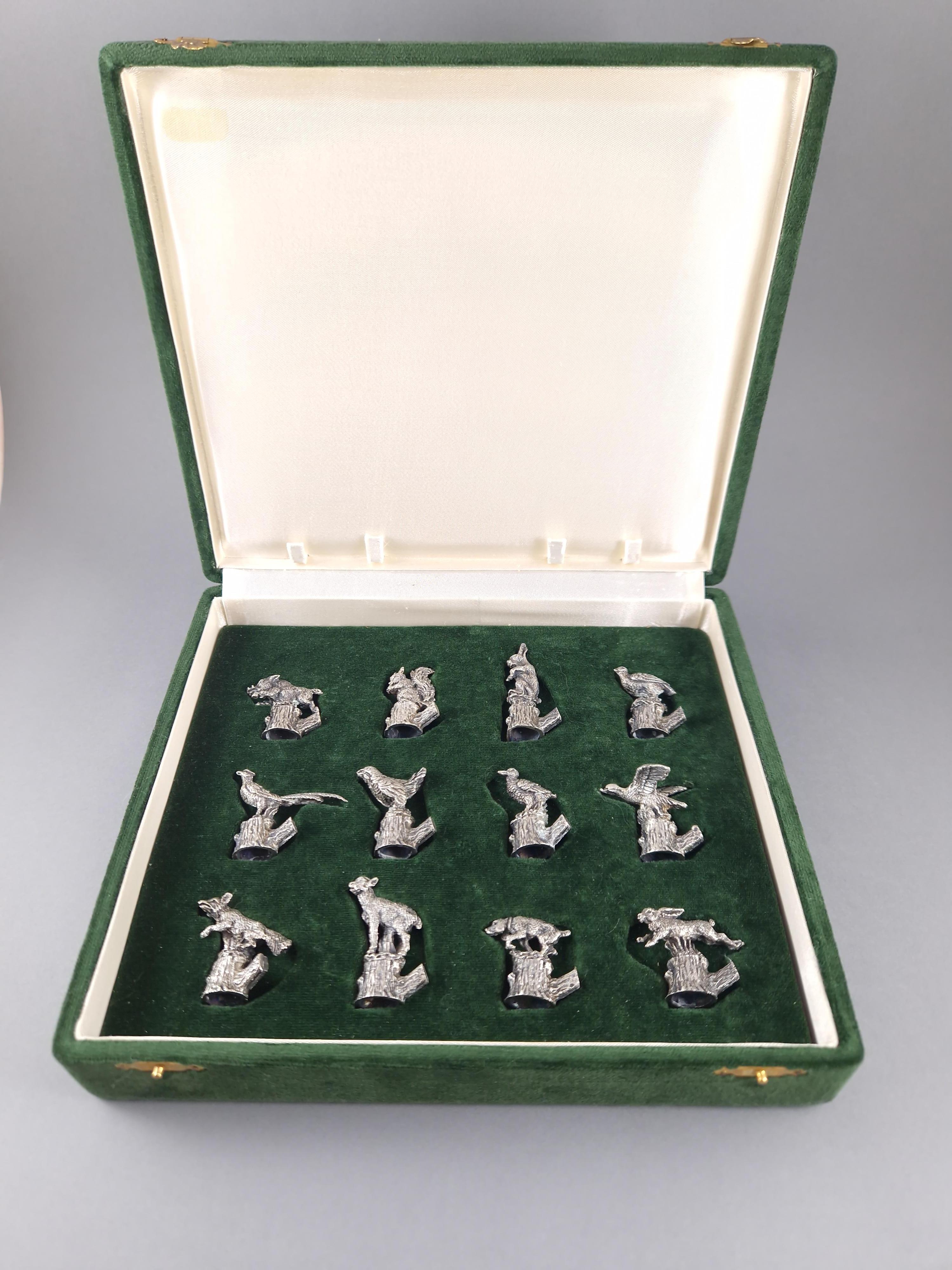 Beautiful set of twelve place card or menu holders in sterling silver  decorated with animals on a wooden trunk 

Silver hallmark 800 
Silversmith: Bartolini Bartolozzi 
Height between 2.9 and 4.8 cm 
Weight: 208 grams 
In its original box