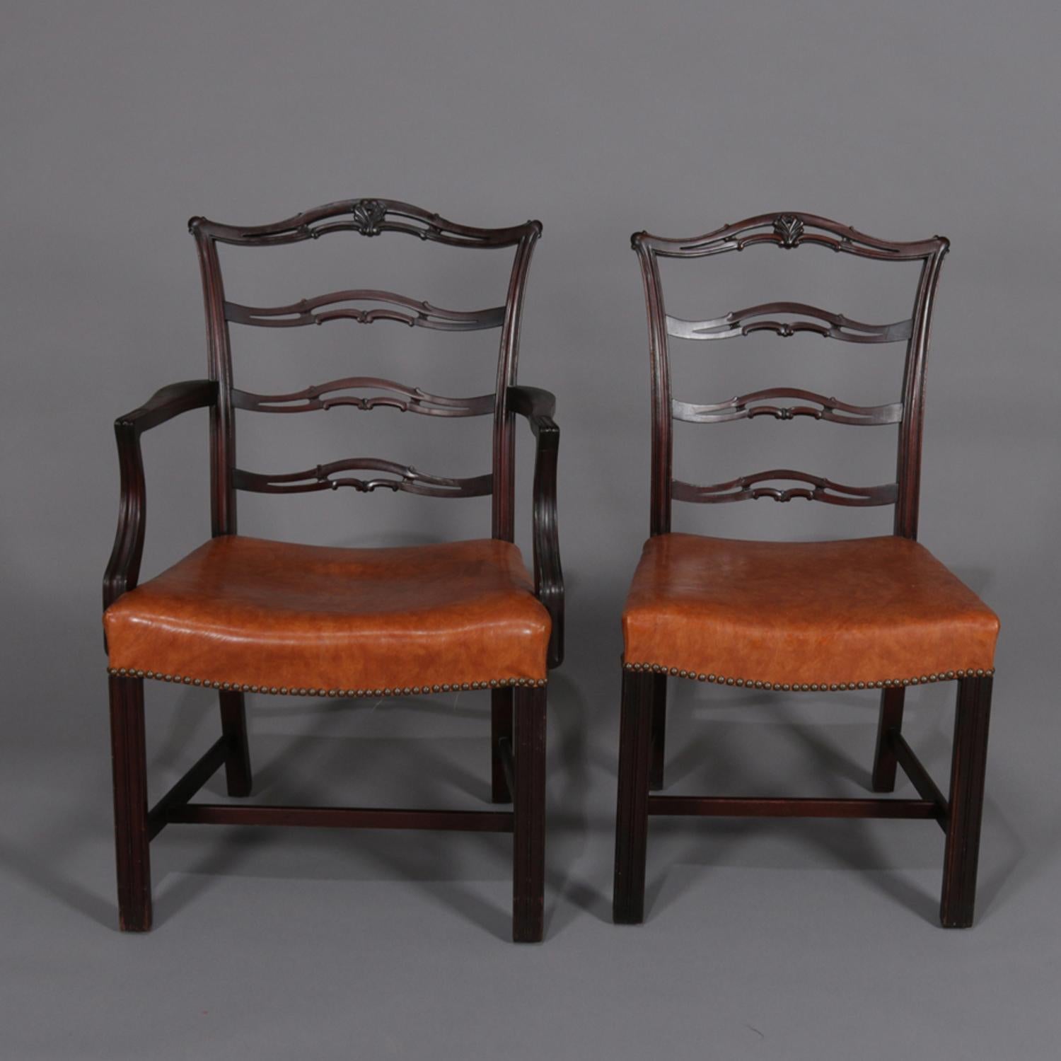 A set of 12 antique Chippendale style ribbon back dining chairs feature mahogany frames with laddered ribbon backs and upholstered seats, includes 2 arm and 10 side chairs, circa 1920.

Measures: Armless 36.5