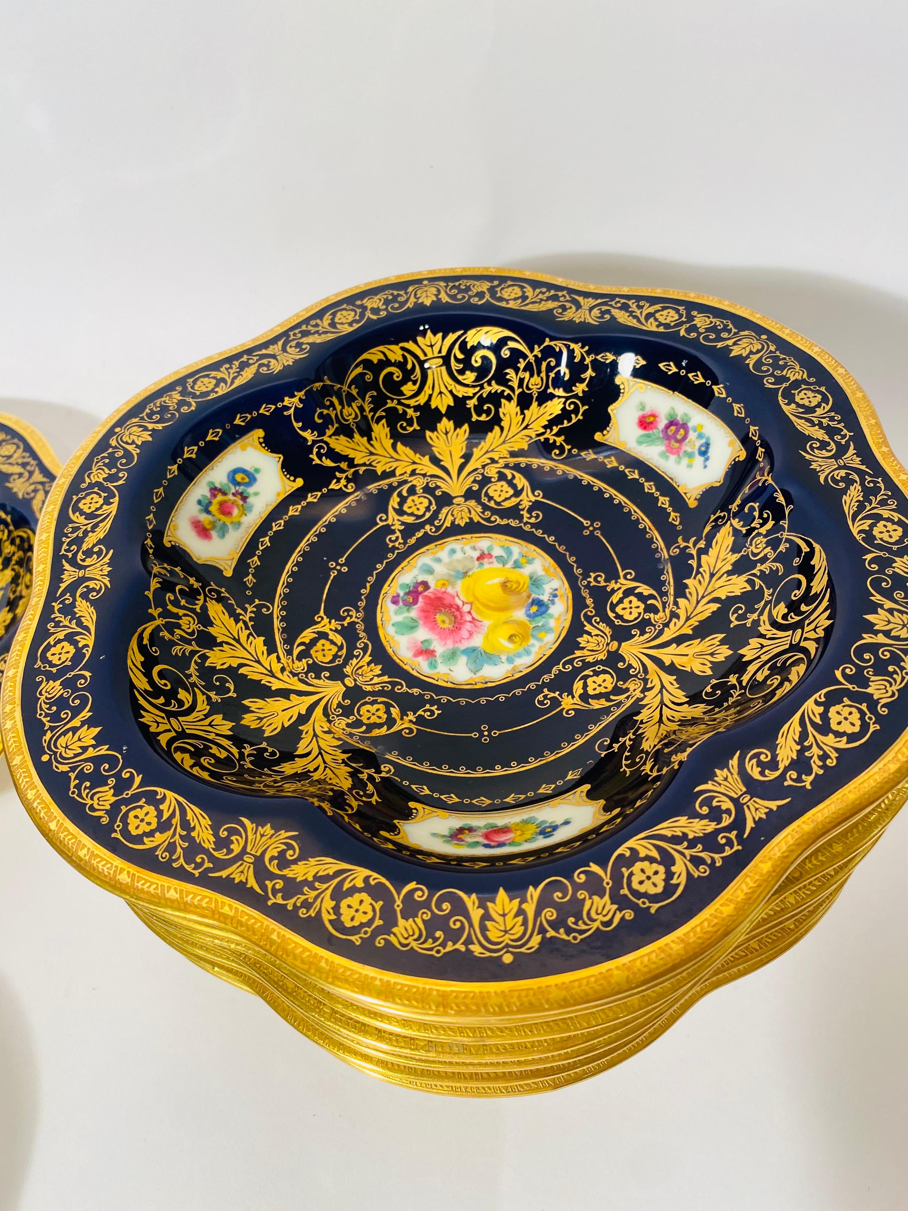 An unique and attractive set of twelve soup or entree bowls from the Black Knight Decorating Studio. The cobalt blue is crisp and uniform and all of the cartouches of florals are different, detailed and very vibrant. A perfect set to mix and match