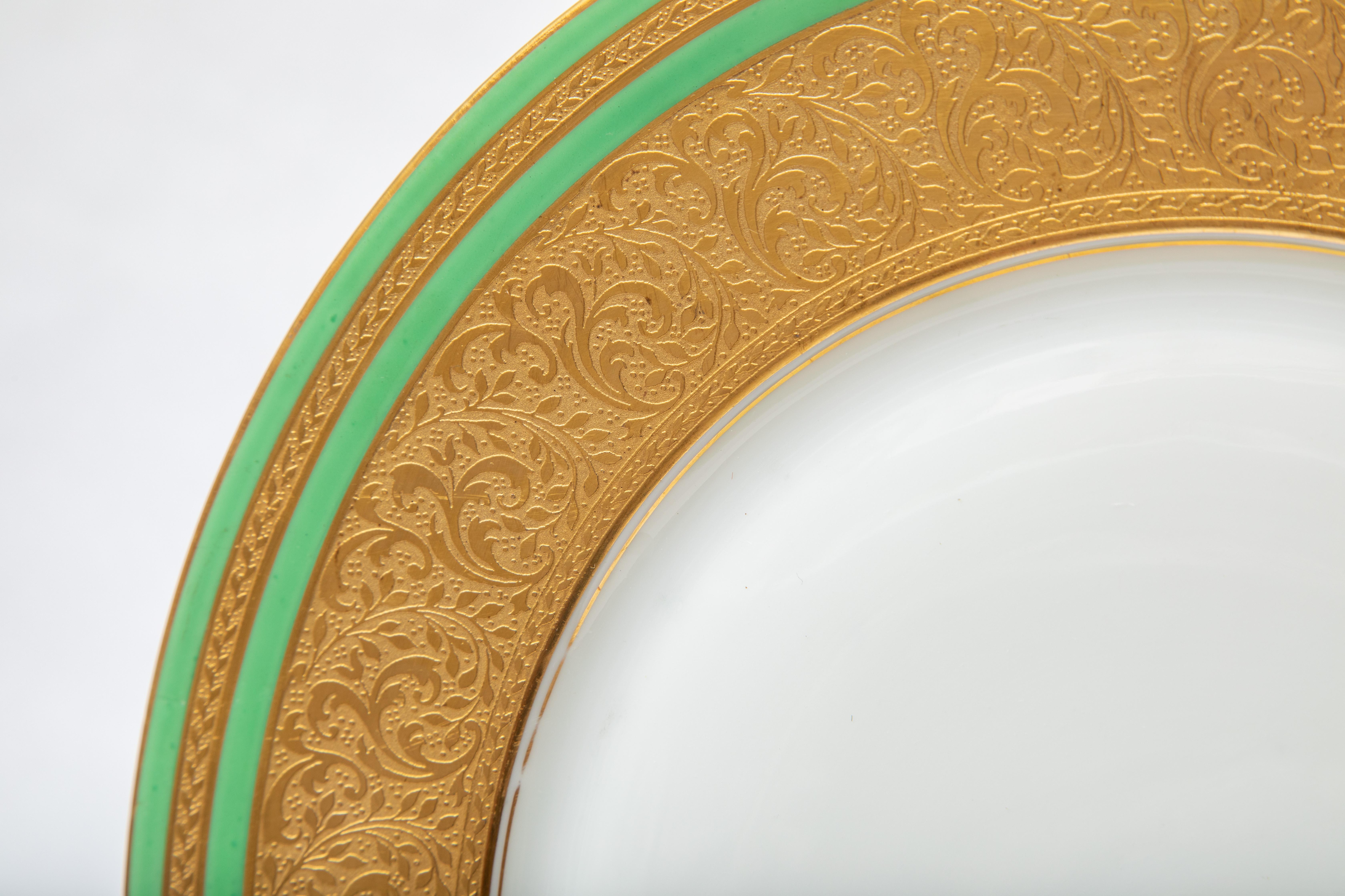 Un elegante set di dodici piatti da portata in porcellana bianca, con elaborati colletti dorati accentati da due bande di verde intenso. Con i centri trasparenti per servire, questi piatti si abbinano perfettamente a tutti i tuoi tavoli. In ottime