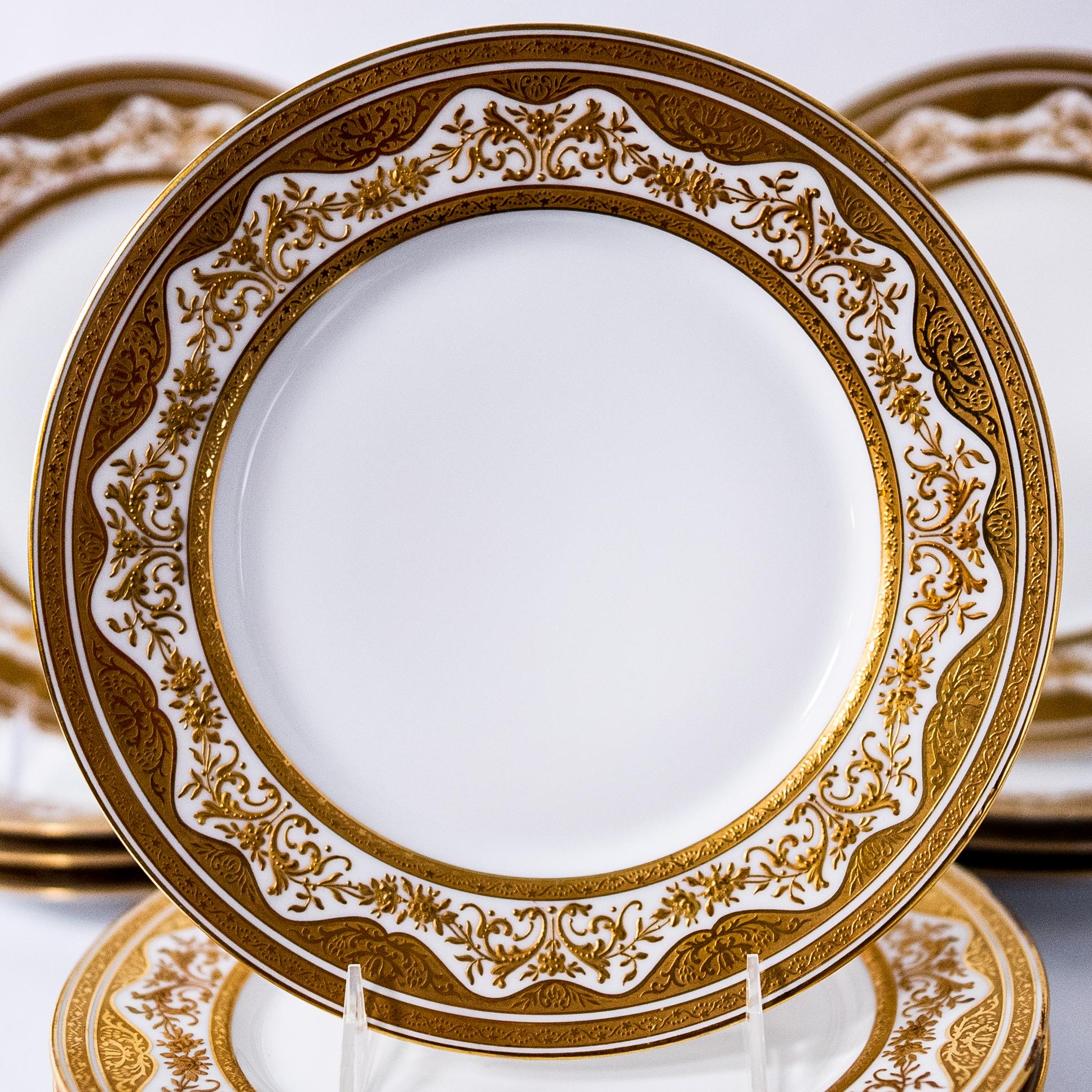 A great set of Continental sized dinner plates with an elaborately decorated raised tooled gilded collar featuring shaped and classic double acid etched 24 karat gold bands. Crisp white porcelain and a custom retailer hall mark: JE Caldwell