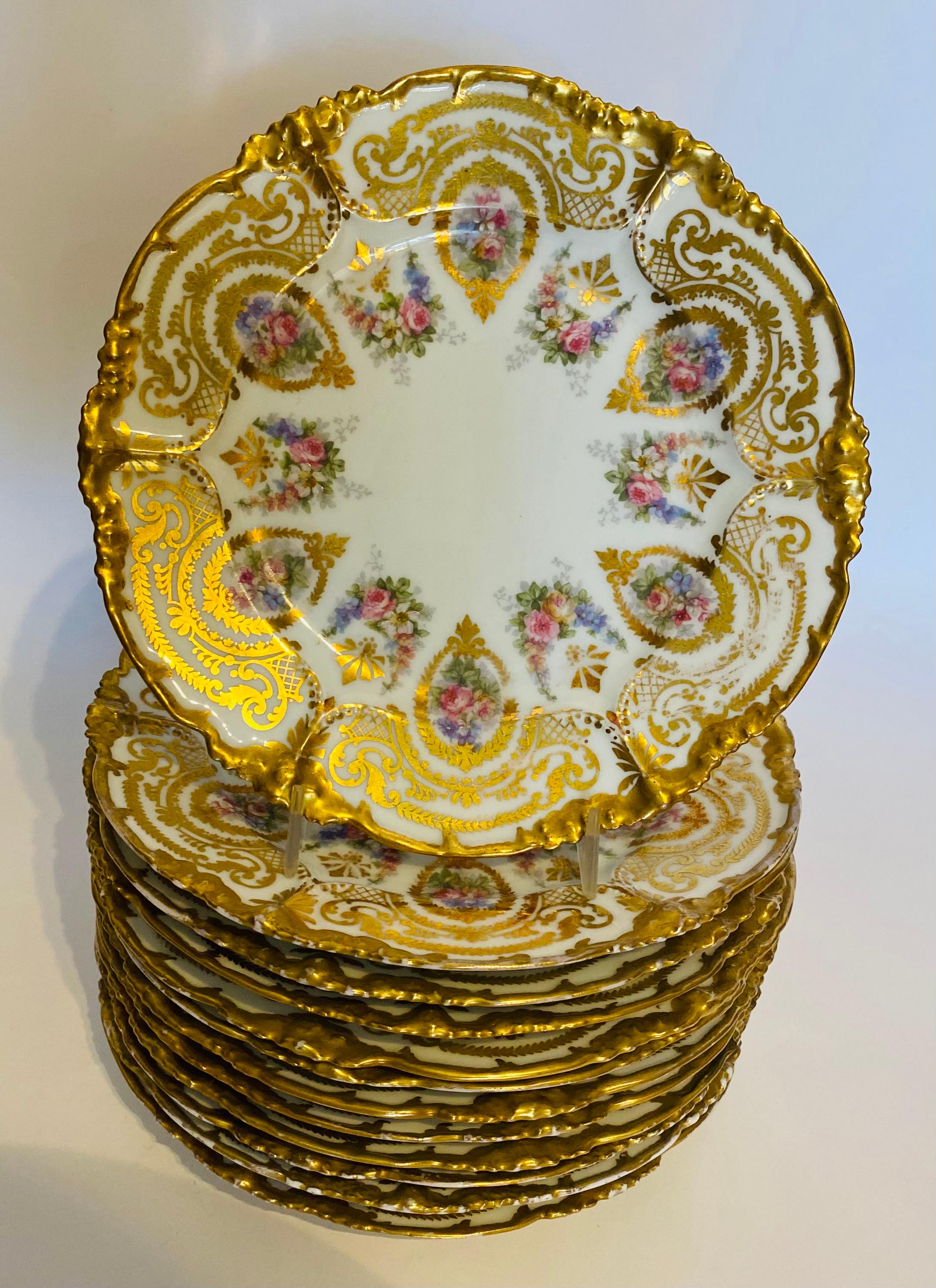 A pretty set of first course or dessert plates by the re known Limoges firm of Jean Pouyat from the turn of the last century. A very versatile size and a great shaped plate accented with multi color florals and lavishly trimmed in 24 karat gold.