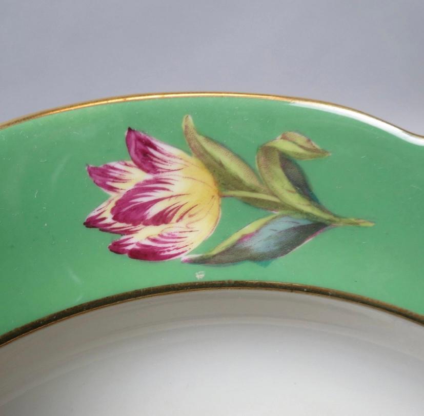 A lovely set of 12 unique botanical hand painted plates custom ordered and retailed through Tiffany & Co from Copeland Spode. This set features a rich green collar with raised white emobossed florals and hand painted cartouches and center designs of