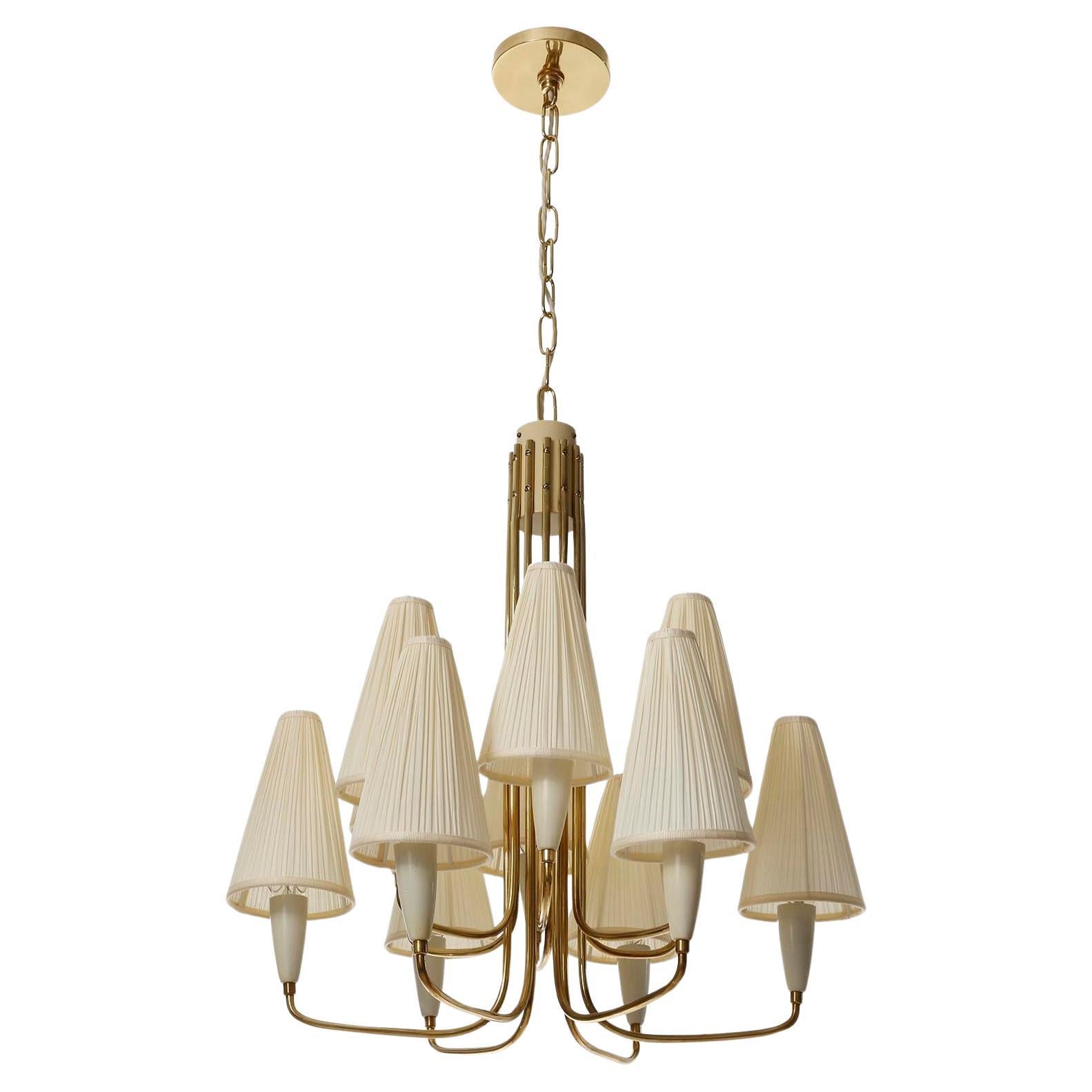 A fantastic twelve-arm Mid-Century Modern pendant chandelier made of brass with organically curved arms and cream colored pleated fabric shades, manufactured by Rupert Nikoll in Austria circa 1960.
The height of the body without chain is 24 inch (60