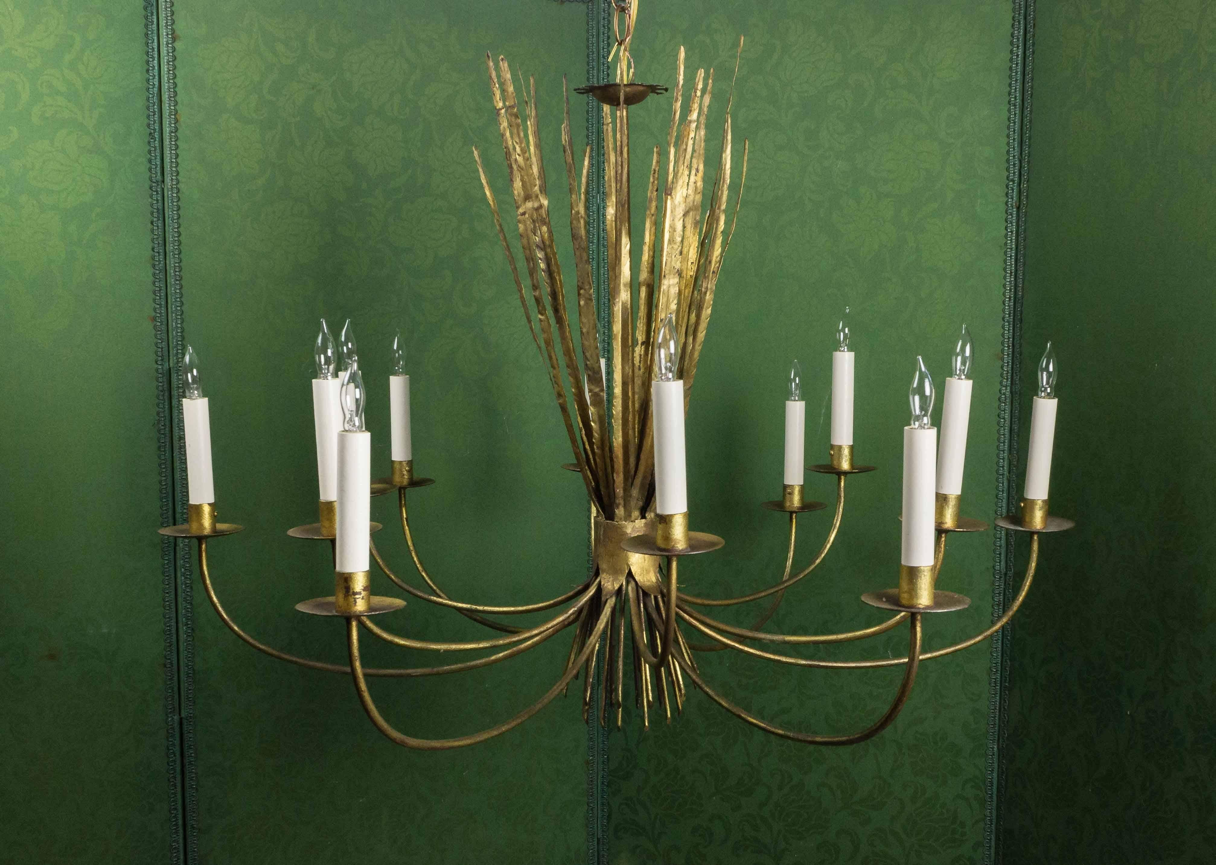 This unique 1940s Spanish gilt metal twelve-arm chandelier is stunning. Featuring a delicate wheat grass motif, this chandelier is enchanting as well as practical. Recently professionally wired and including a new canopy, this vintage piece is in