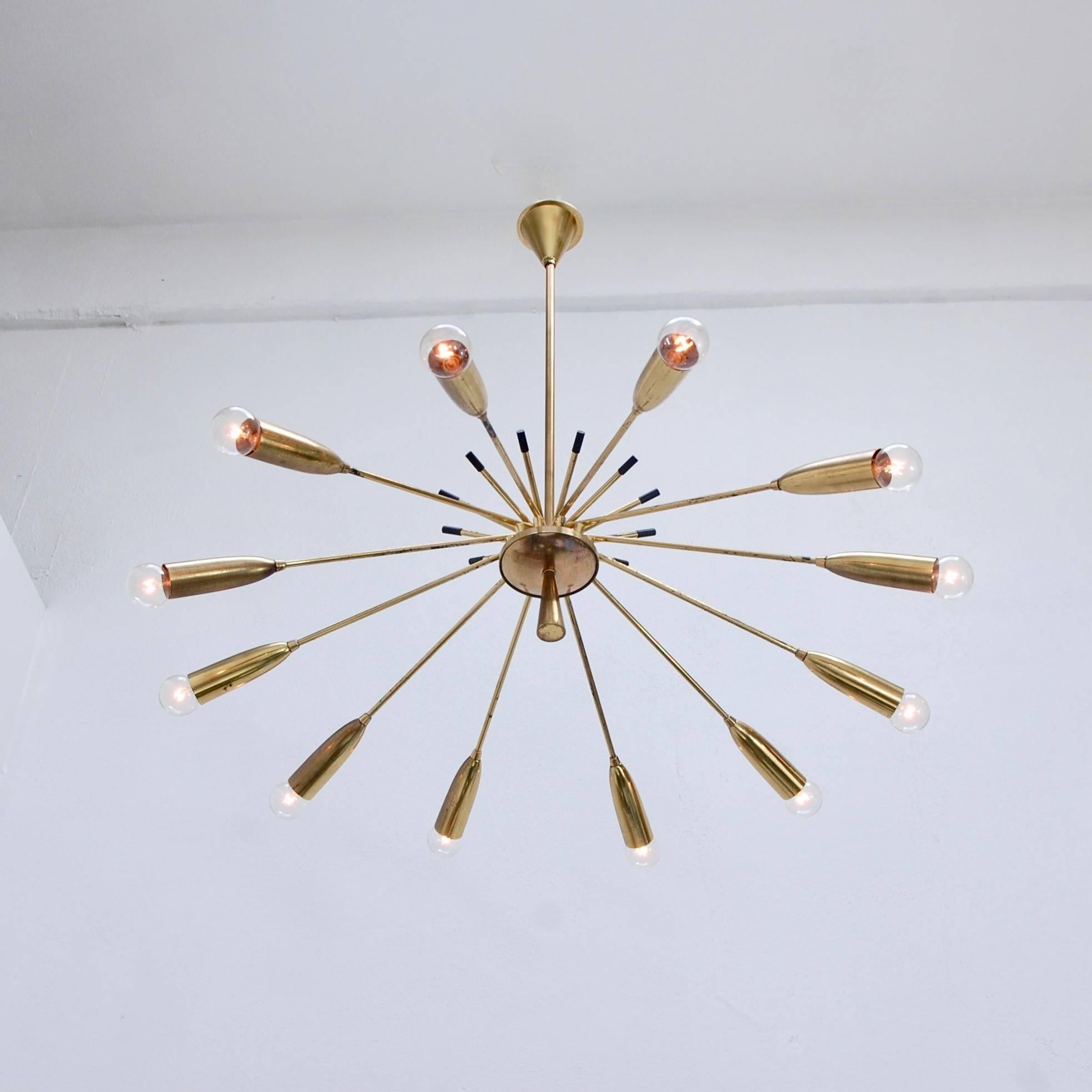 Stunning twelve-arm Italian modernist chandelier light fixture from the 1950s. Original brass finish. Rewired for use in the US. Candelabra based E12 sockets.
Measures: Fixture height 9”
Diameter 37”
OAD 32”.
   