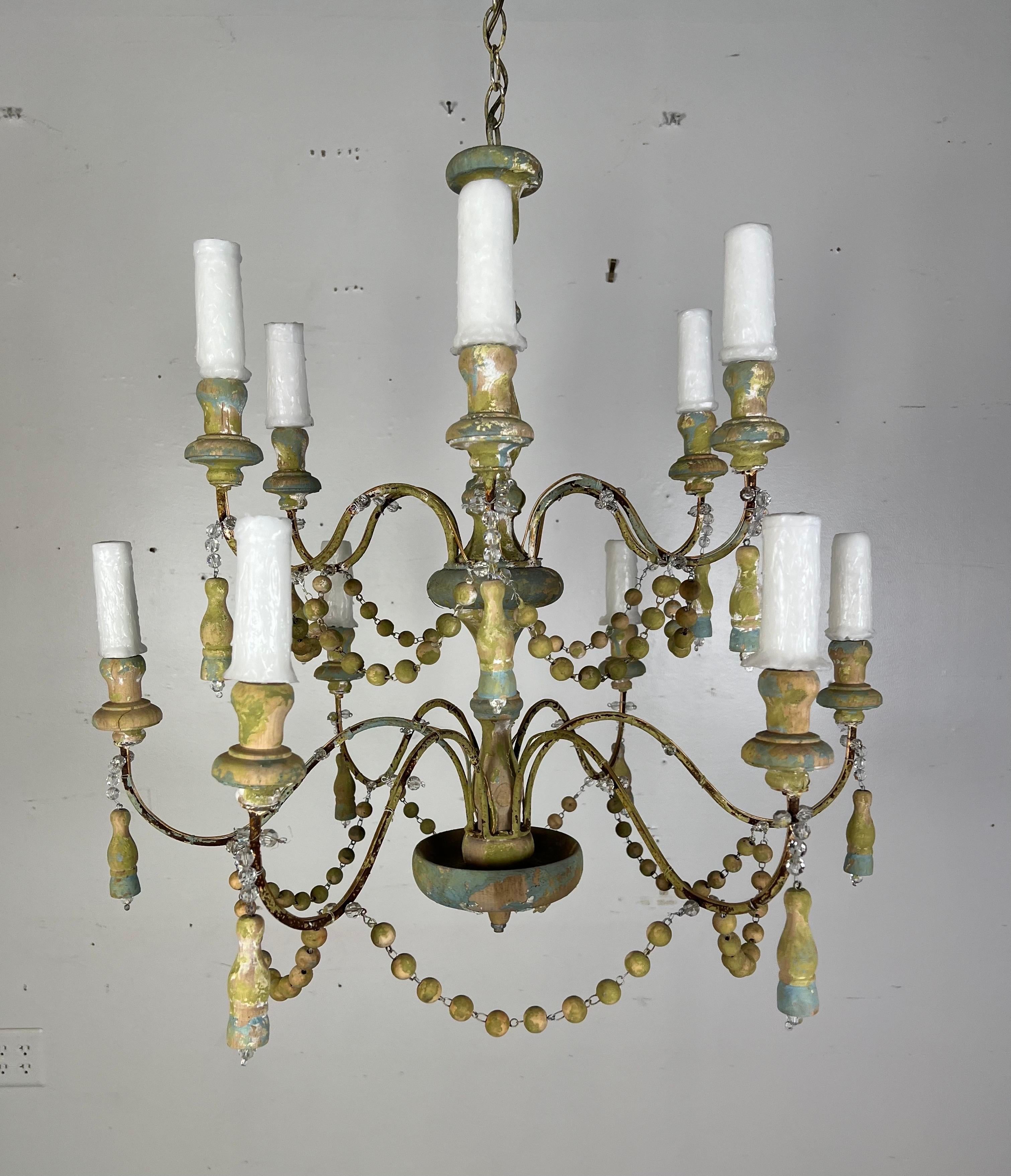 Stunning Italian painted two-tier chandelier.  This chandelier, with its multiple layers, cascades light elegantly through beaded garlands that drape between each tier.

Adorning this chandelier are tassels that hang gracefully, adding a sense of