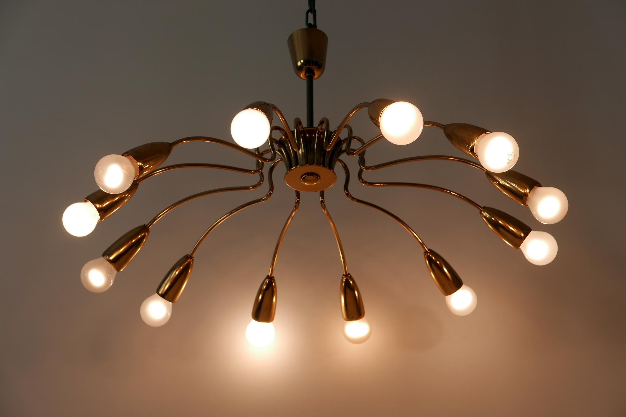 Gorgeous twelve-armed Mid-Century Modern sputnik chandelier or pendant light. Designed and manufactured in Germany, 1950s.

Executed in brass, the chandelier needs 12 x E27 screw fit bulbs. It works both with 110 / 230 volt.

Good original