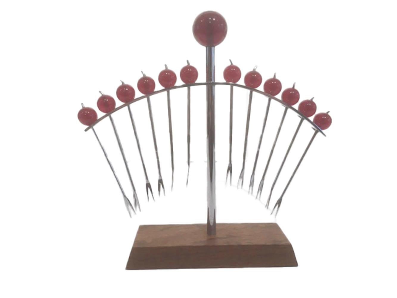 12 ball topped chrome cocktail picks with forked tips and red knops with chrome stems held in a 