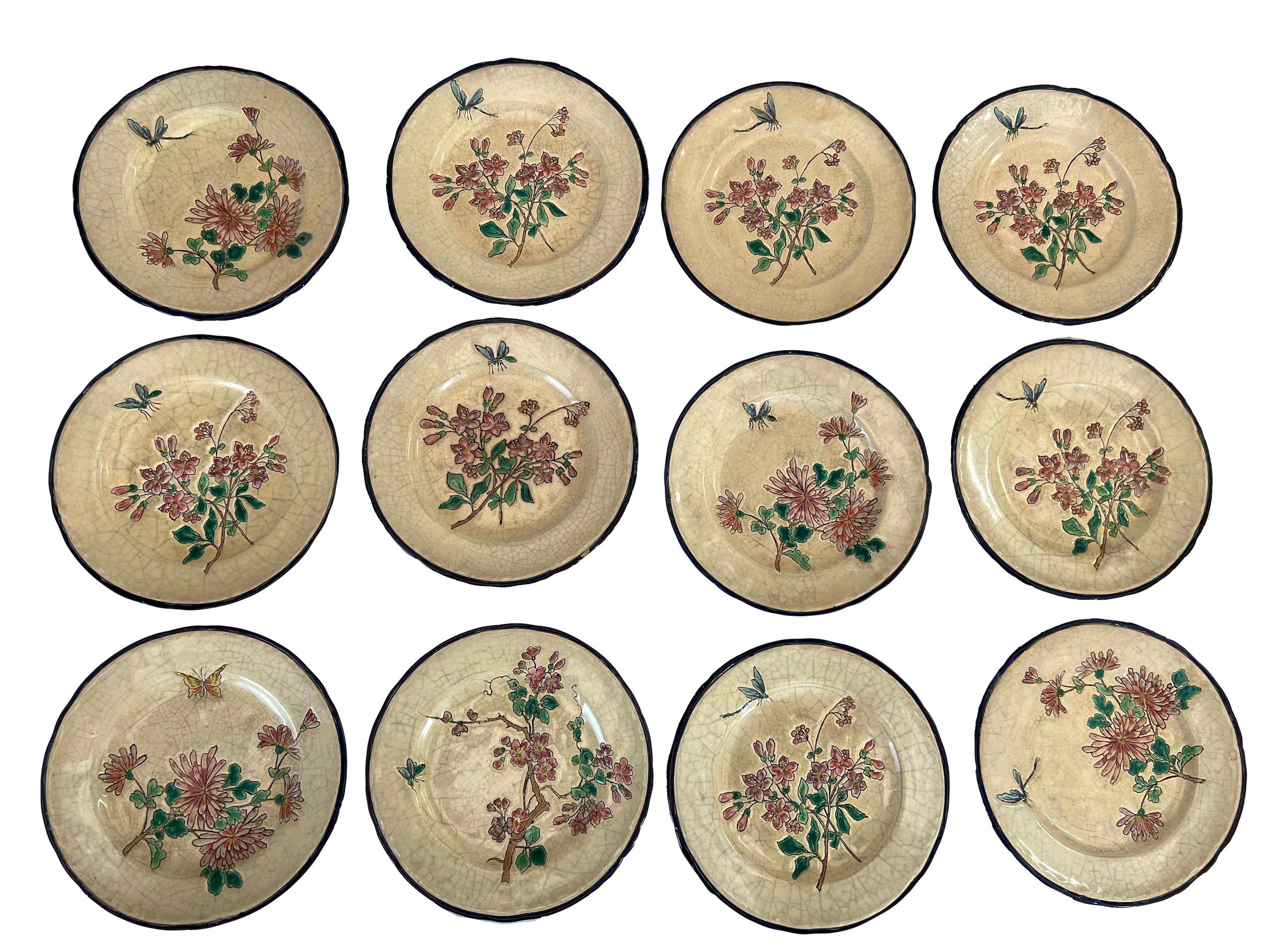 Das Ensemble besteht aus 12 Assietten zum Dessert in Longwy-Emaux. Jedes Assiette ist einzigartig und zeigt ein Blumenmuster in Begleitung eines Insekts in einem japanischen Stil. Sie sind raffiniert dekoriert und können zur Gestaltung eines