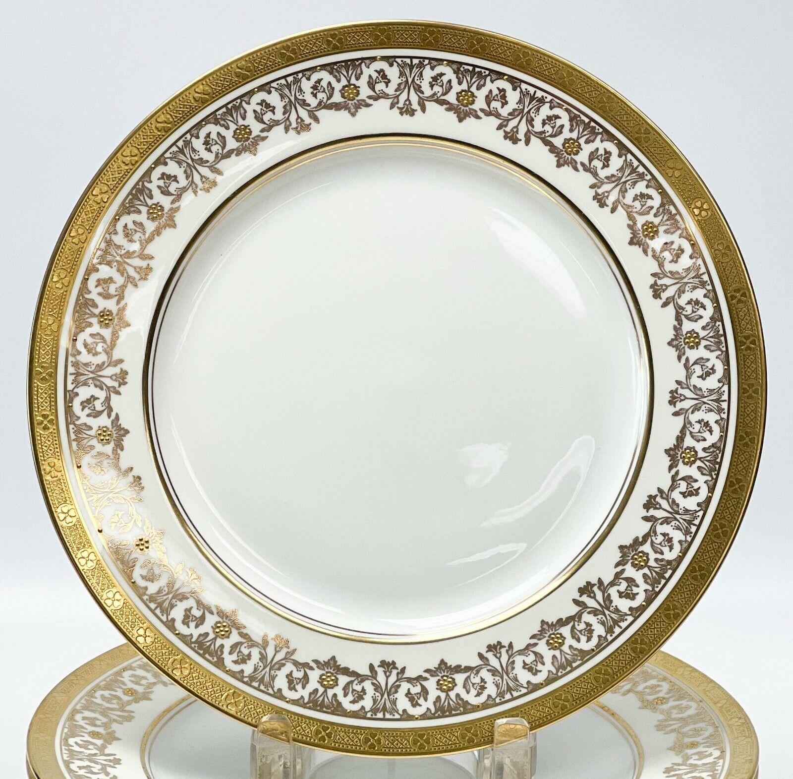 12 Aynsley England Porcelain Dinner Plates in Kenilworth Ivory, circa 1940

A white center with an off-white ground to the edge with ornate gilt foliate decoration with raised gold floral accents. A geometric floral pattern to the gilt rims.
