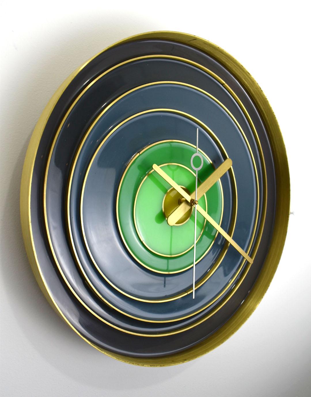 This stunning clock is made of a single spun piece of solid brass.  It is  designed with inlaid varying sized brass rings and then filled with tinted epoxy poured.   The hour and minute hands are hand cut, a continuous sweep hand mechanism has been